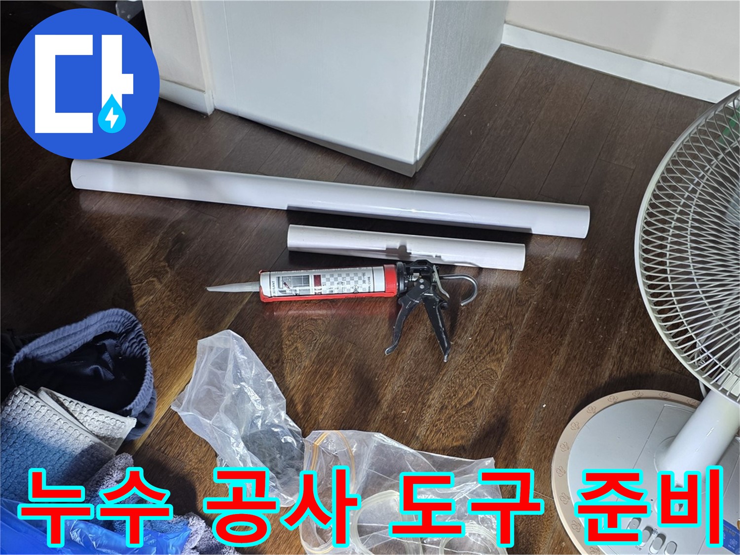 누수 공사를 위한 도구 준비 - 실리콘 건과 다양한 배관 자재들이 준비되어 있습니다.