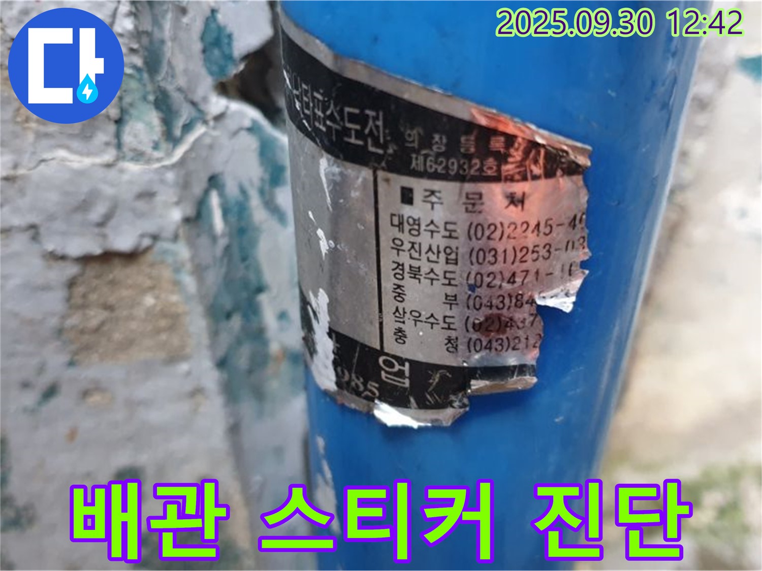 오래된 수도 배관에 부착된 스티커 - 여러 시공 업체의 연락처 정보가 상세하게 기재되어 있습니다.