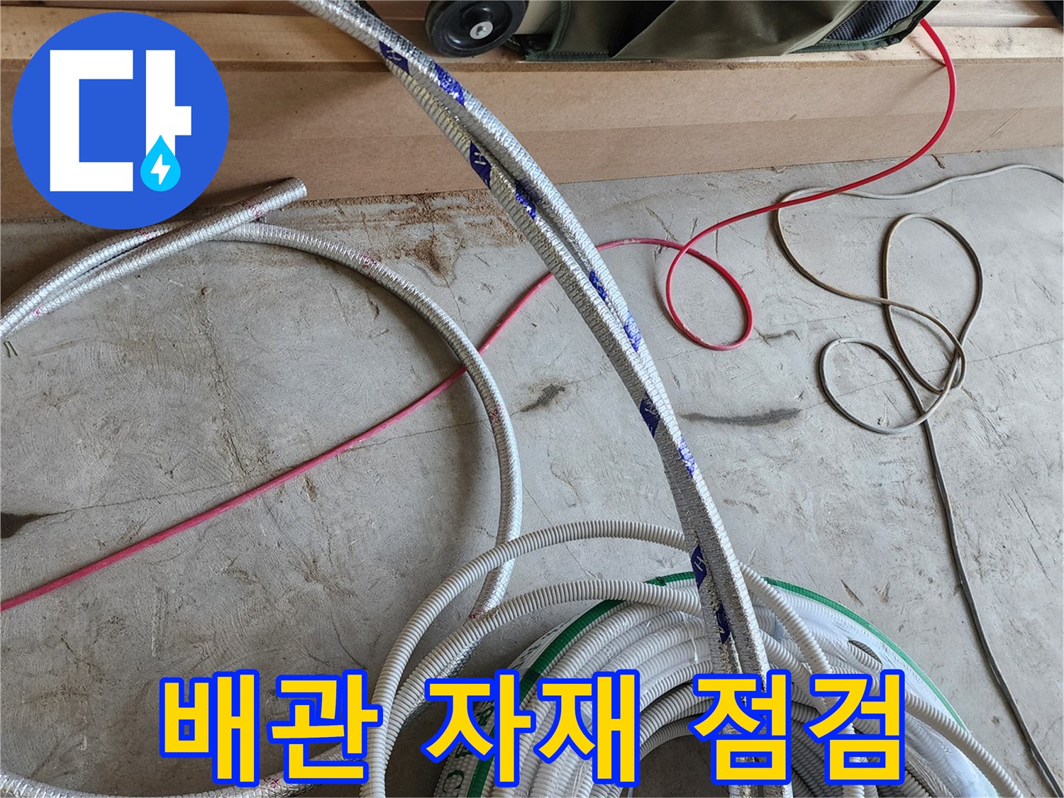 공사 현장에 놓인 은색 배관 자재와 붉은 선의 모습