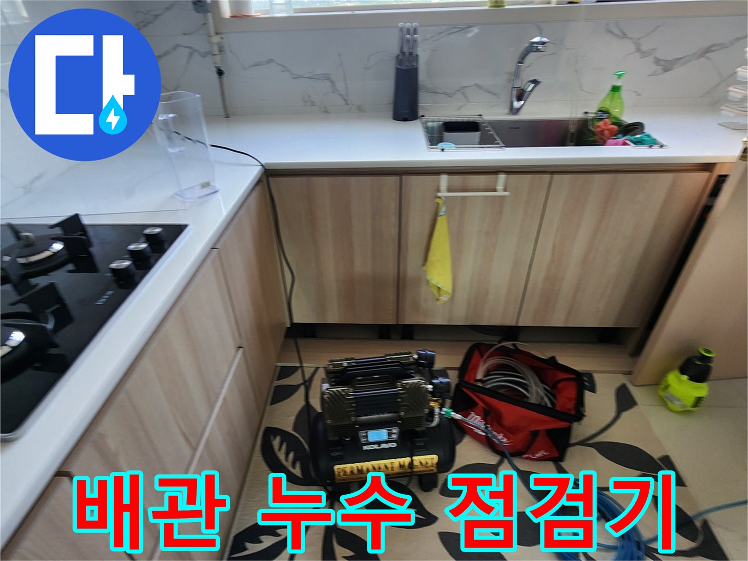 싱크대 하단 공간에 설치된-배관 압력 테스트 장비와 탐지용 호스