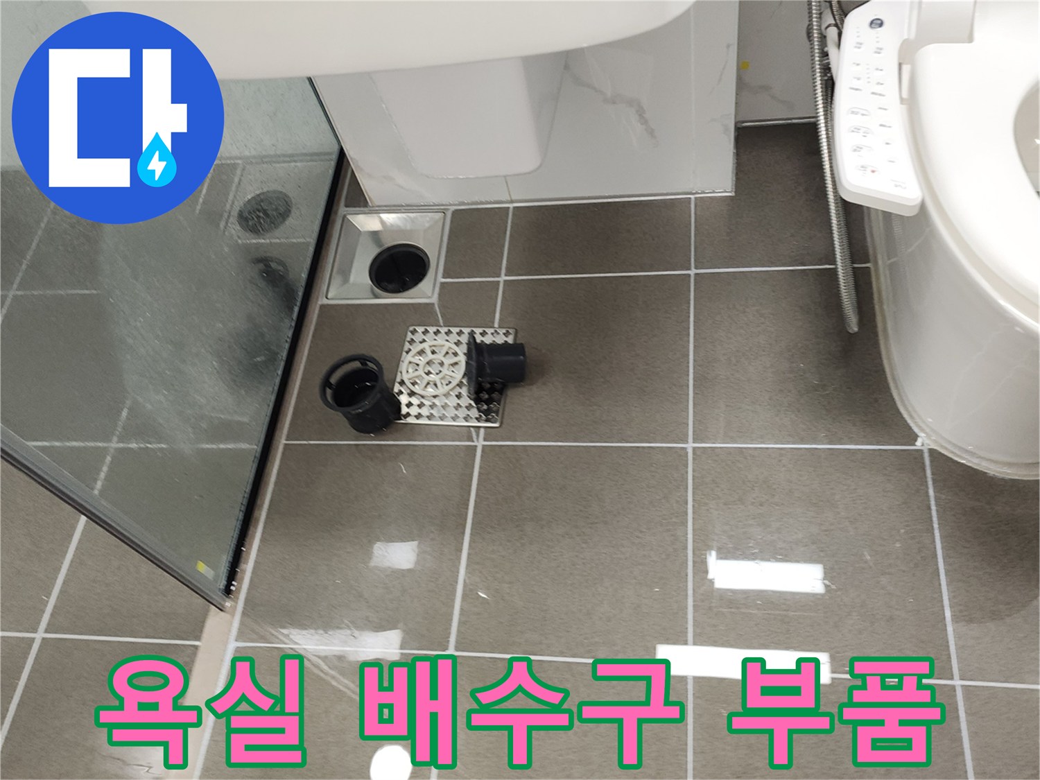 욕실 바닥 배수구 주변에 분리된 배관 부속과 유가 덮개 이미지