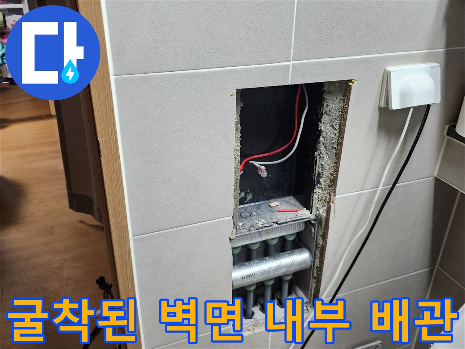 욕실 타일을 제거하여 드러난 은색 배관과 전기선 노출 부위