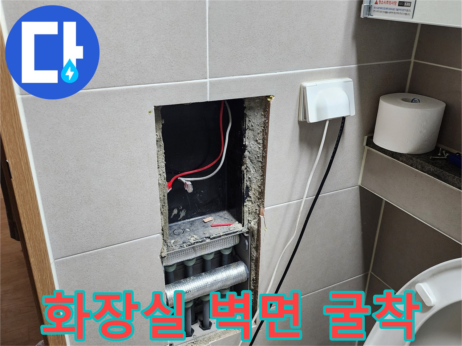 타일 제거 후 노출된 배관과 전기 콘센트 주변부