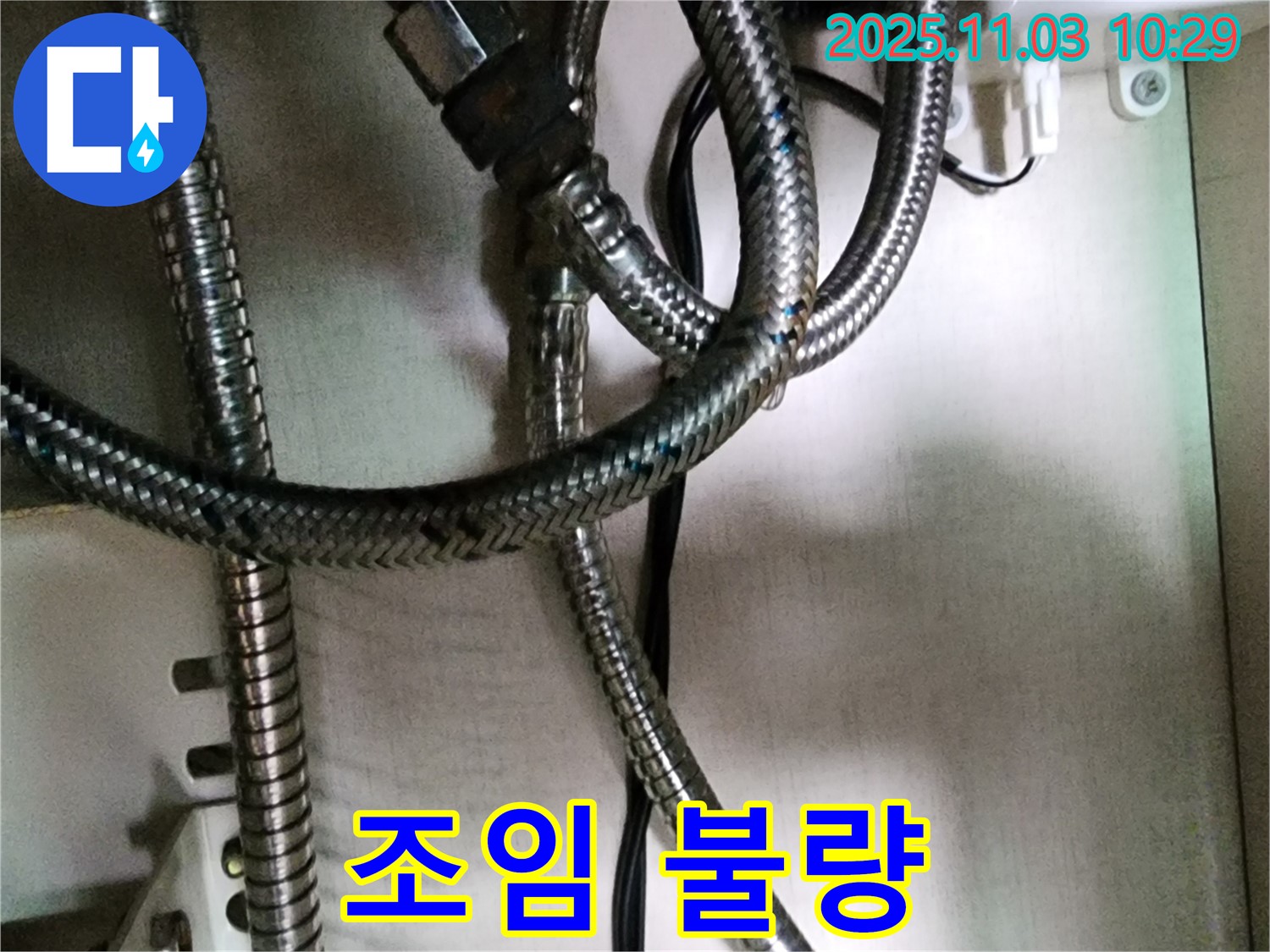 세탁기 급수 호스 연결 부위가 제대로 조여지지 않아 누수가 발생하는 모습 - 간단한 조임 작업으로 해결 가능합니다.
