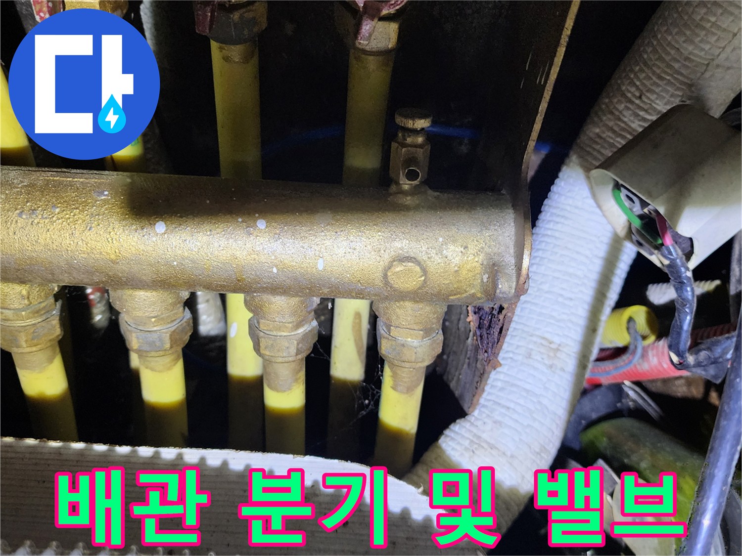 노란색 배관이 여러 갈래로 나뉘어 연결된 싱크대 하부 배관 구조입니다.