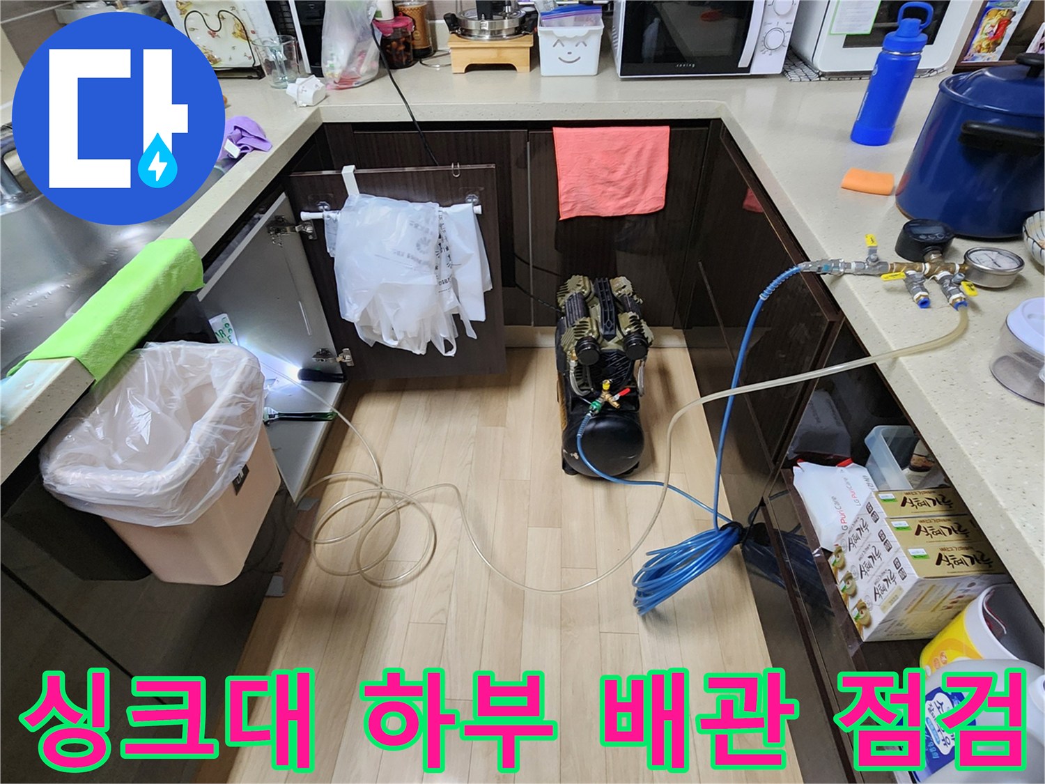 주방 싱크대 아래쪽-압력 측정을 위해 연결된 공압 장치와 호스들