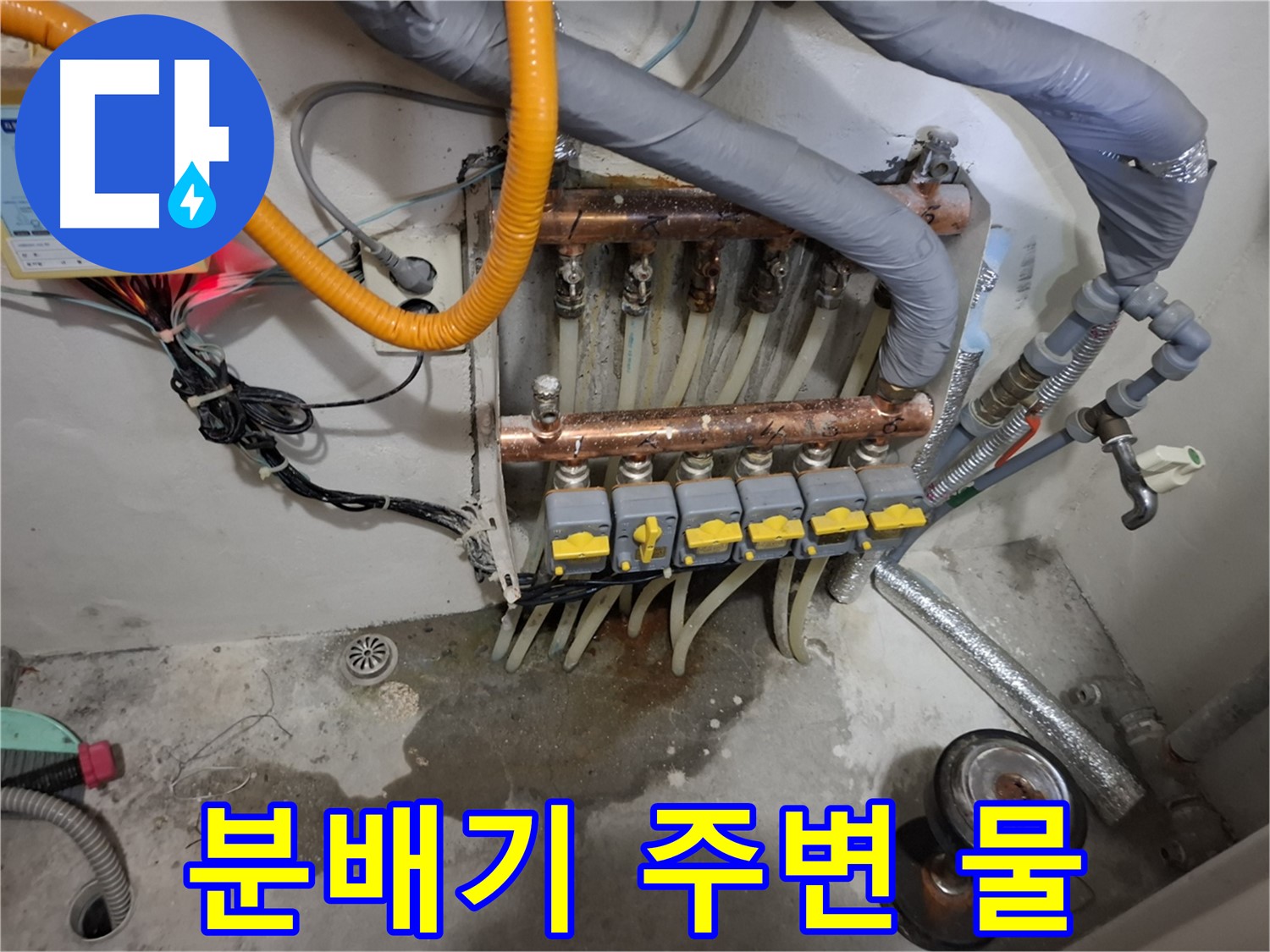 분배기 주변 물 - 분배기 주변에 물이 흥건하게 고여 있어 누수가 심각해 보입니다.