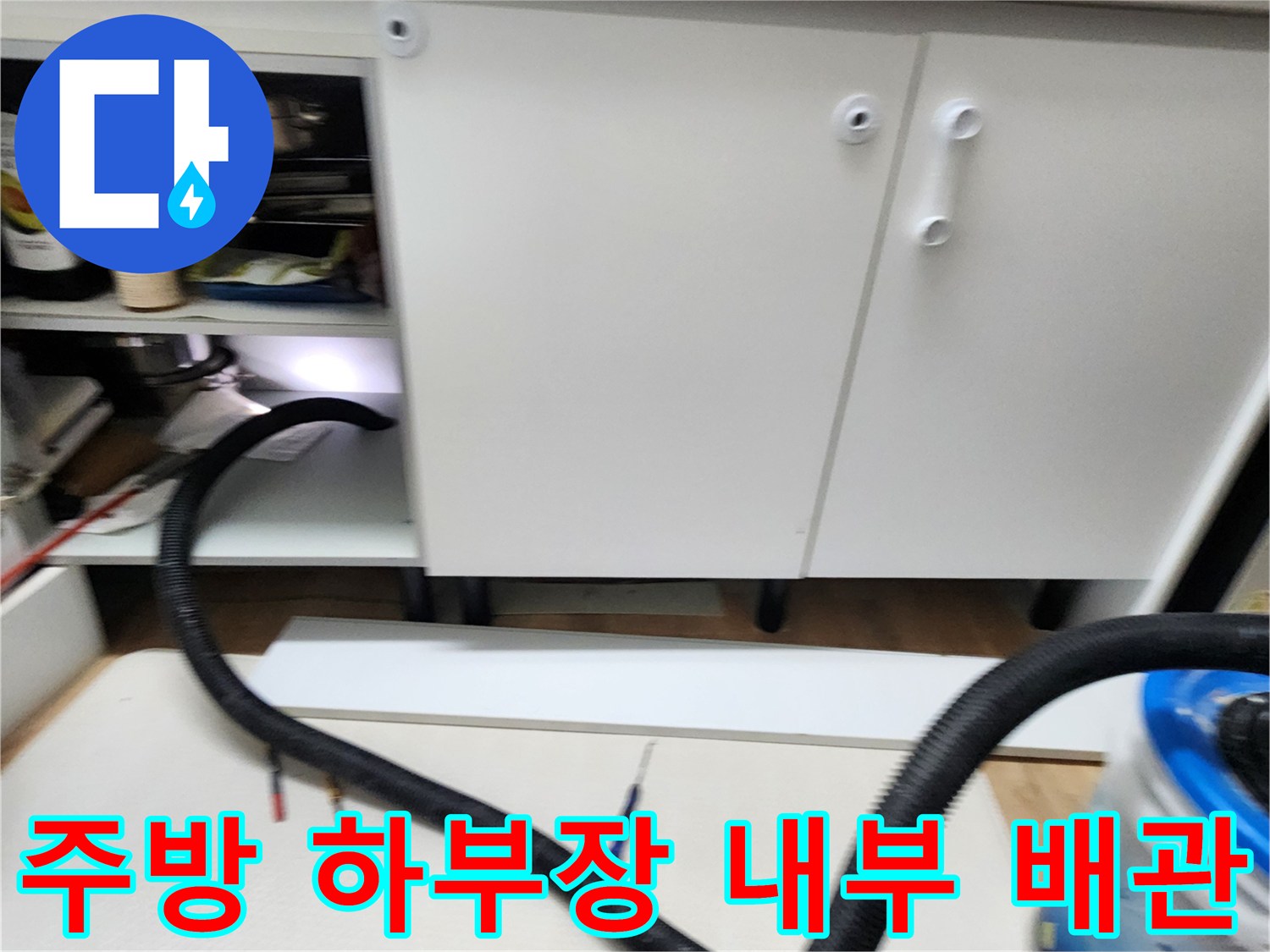싱크대 아래쪽 배관과 주변 장비가 배치된 현장 사진입니다.