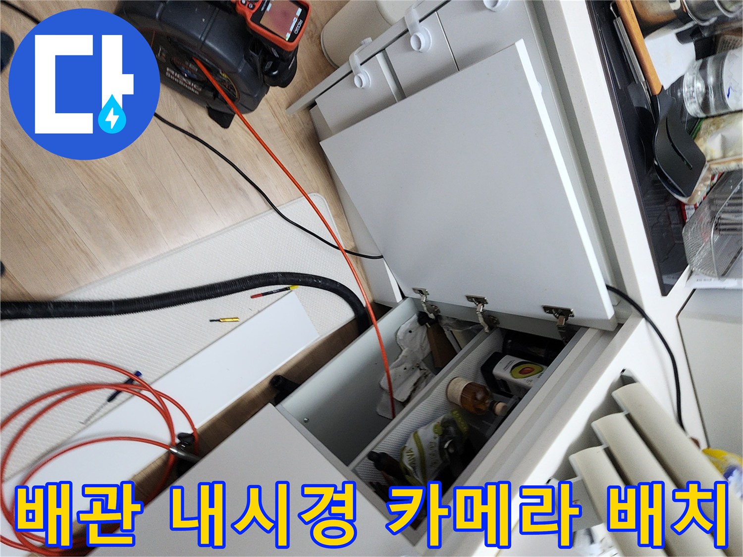 싱크대 하단 공간에 놓인 배관 검사용 내시경 장비