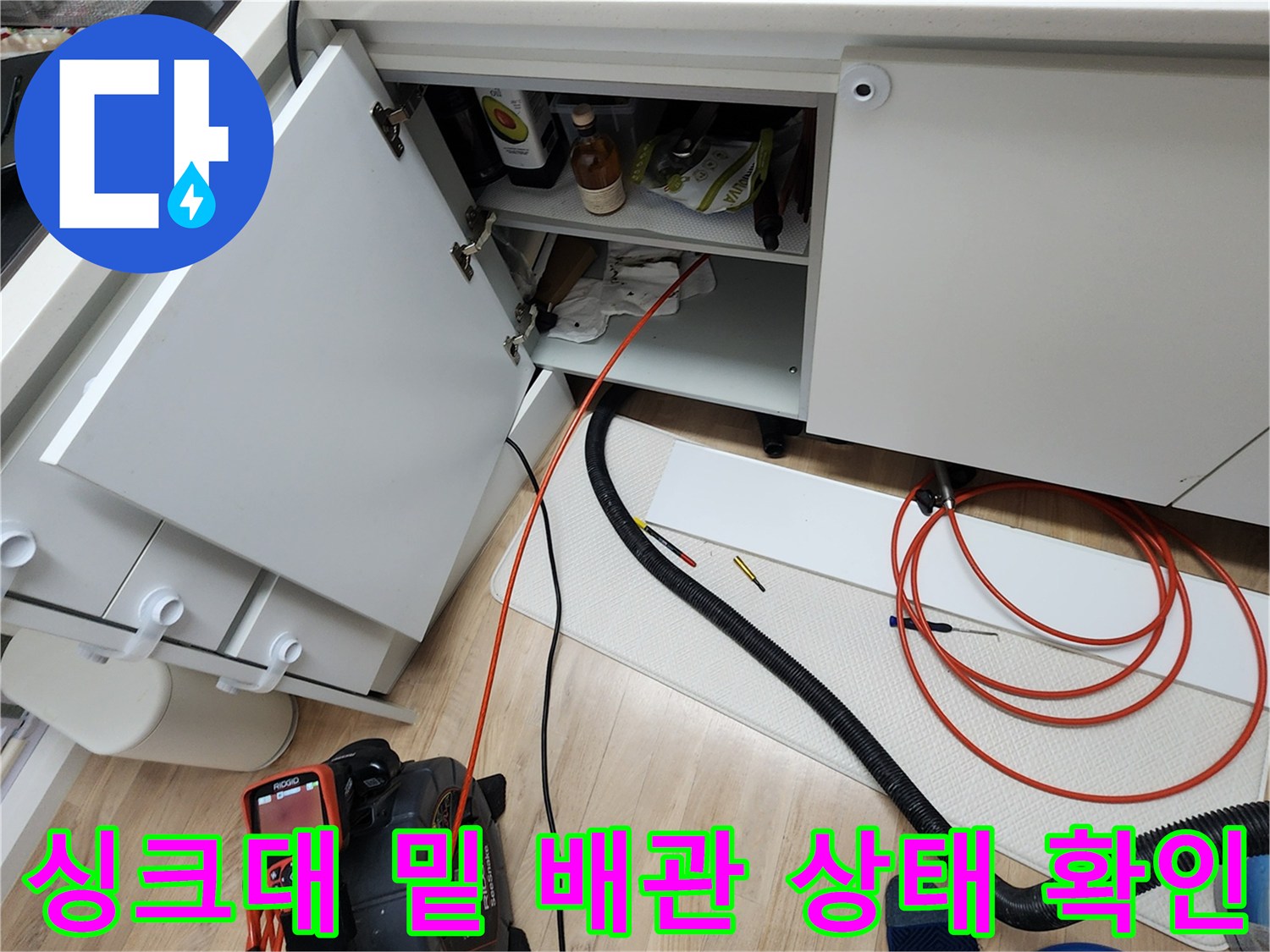 싱크대 하부장 내부와 바닥 배관 장비 연결 모습