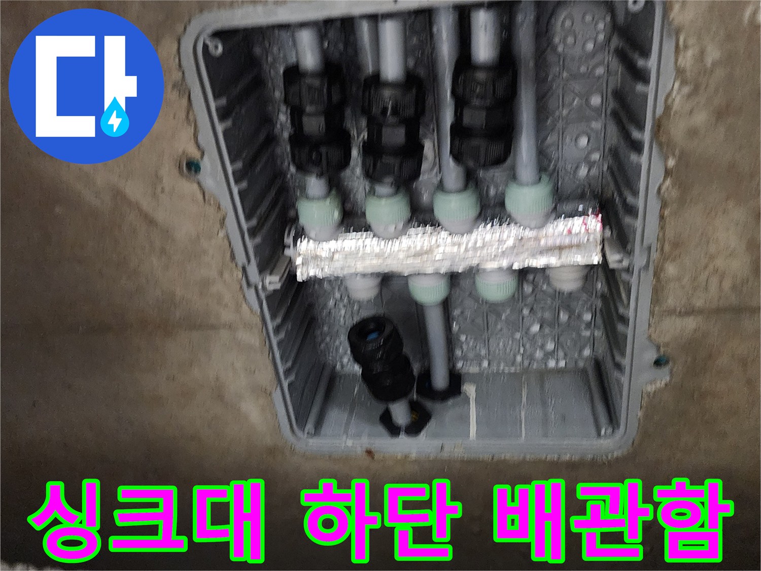 주방 싱크대 아래 매립된 분배기 내부 모습 - 배관 연결 부위 점검 중
