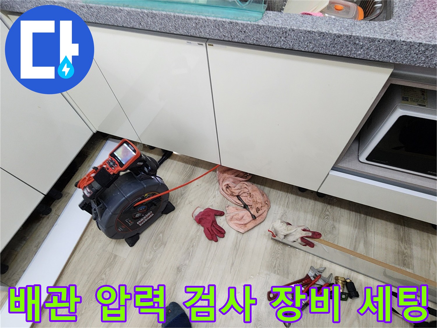 싱크대 아래 공간에 배치된 디지털 압력계와 작업용 도구들입니다.