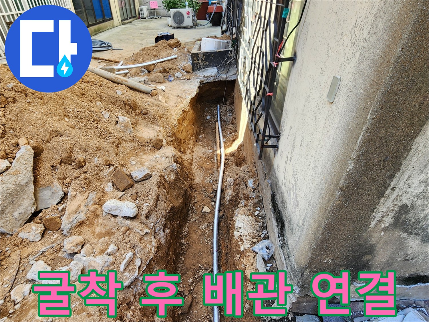 건물 외벽 옆 흙을 파내어 드러난 새 배관 설치 현장