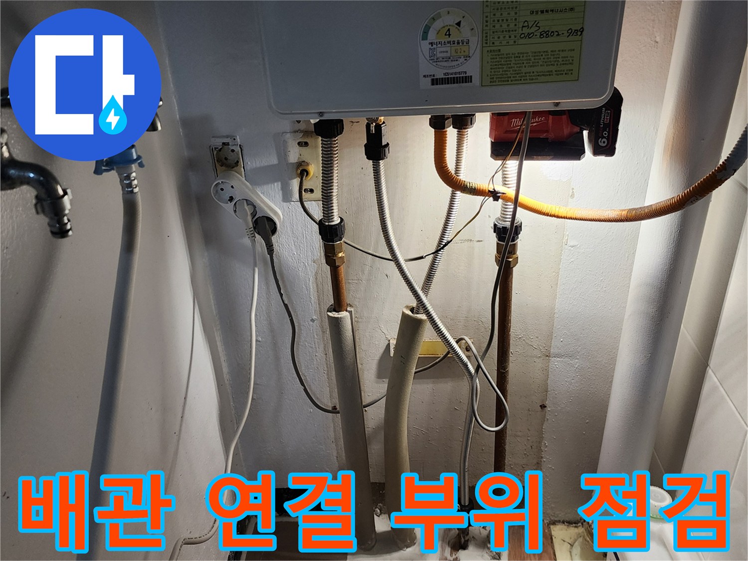 보일러 아래 배관의 결합 상태를 근접 촬영한 이미지