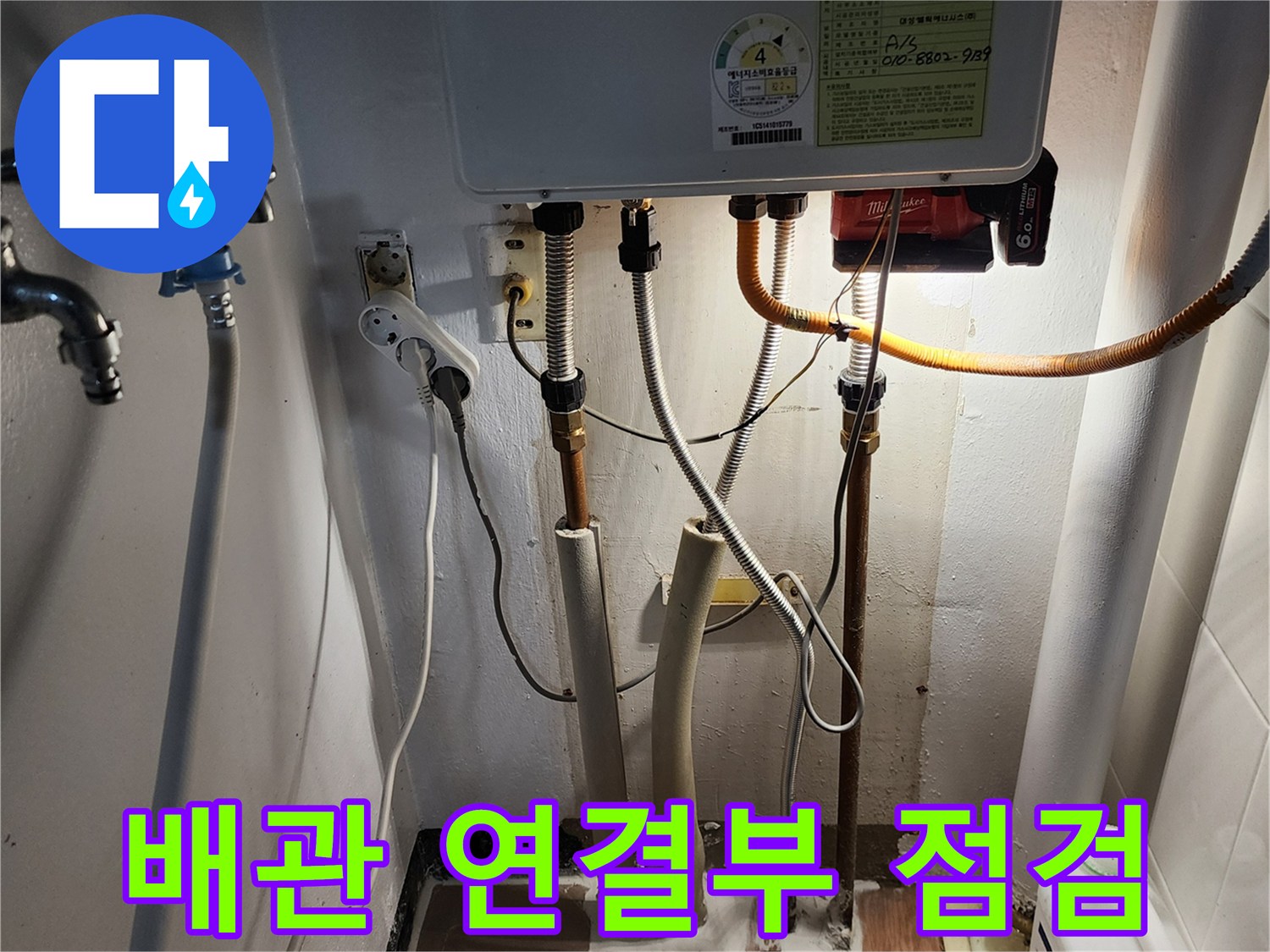 보일러 하단 급수 밸브와 배수 호스 연결 부위 상세 사진