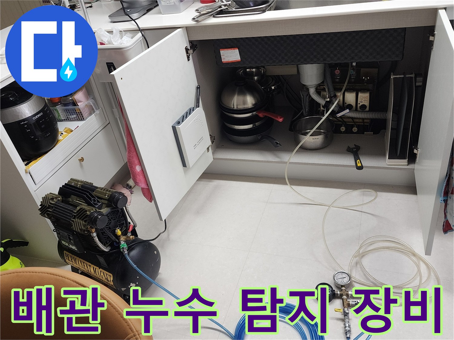 싱크대 하부 배관 점검을 위해 설치된 공압 테스트기와 호스
