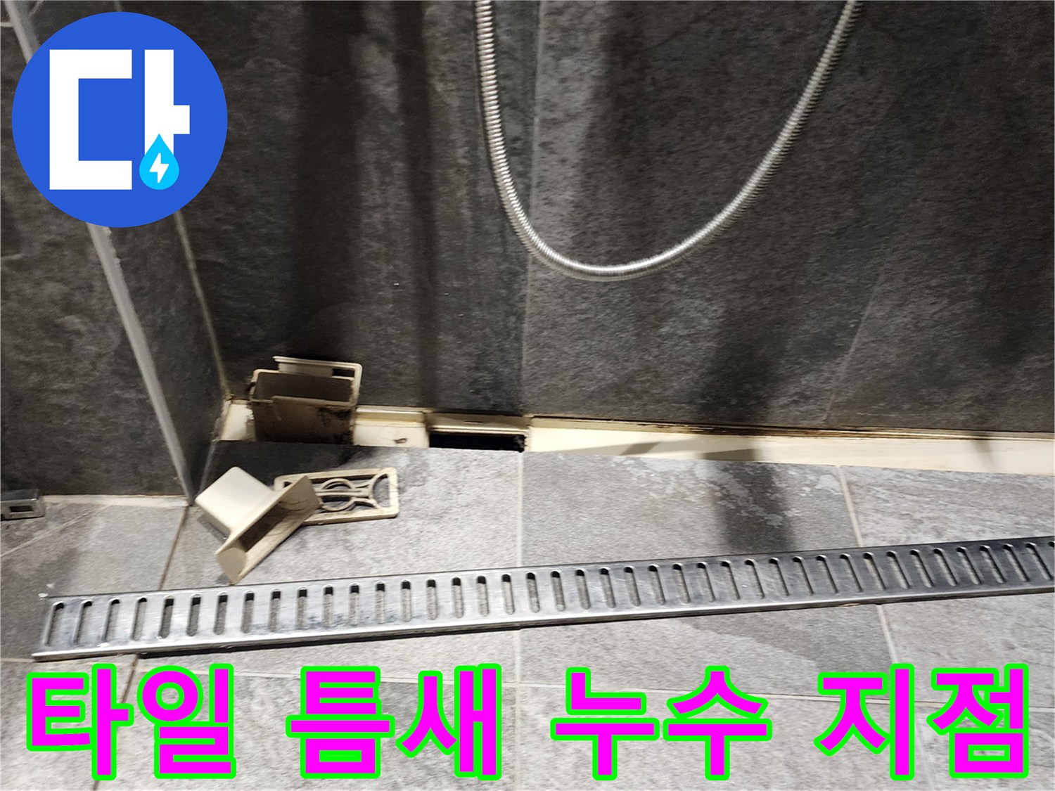 화장실 바닥 타일과 배수구 사이의 벌어진 공간을 정밀하게 촬영한 사진