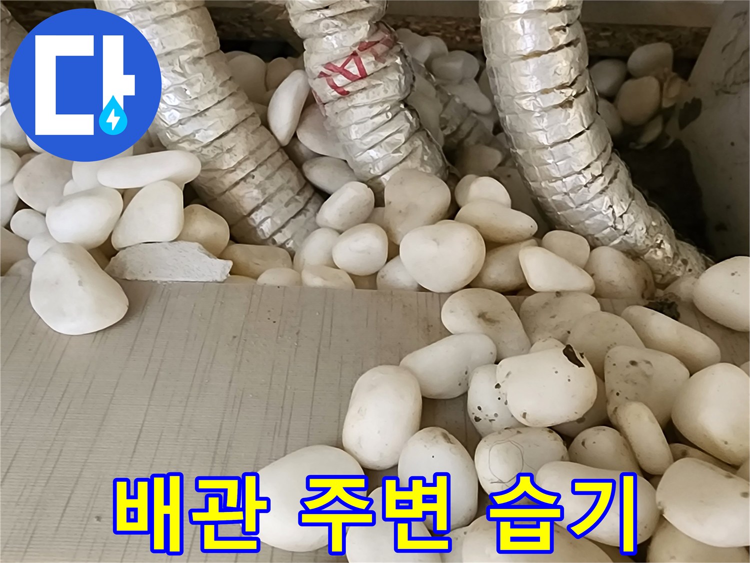 습기를 머금어 젖은 배관 주위의 자갈들