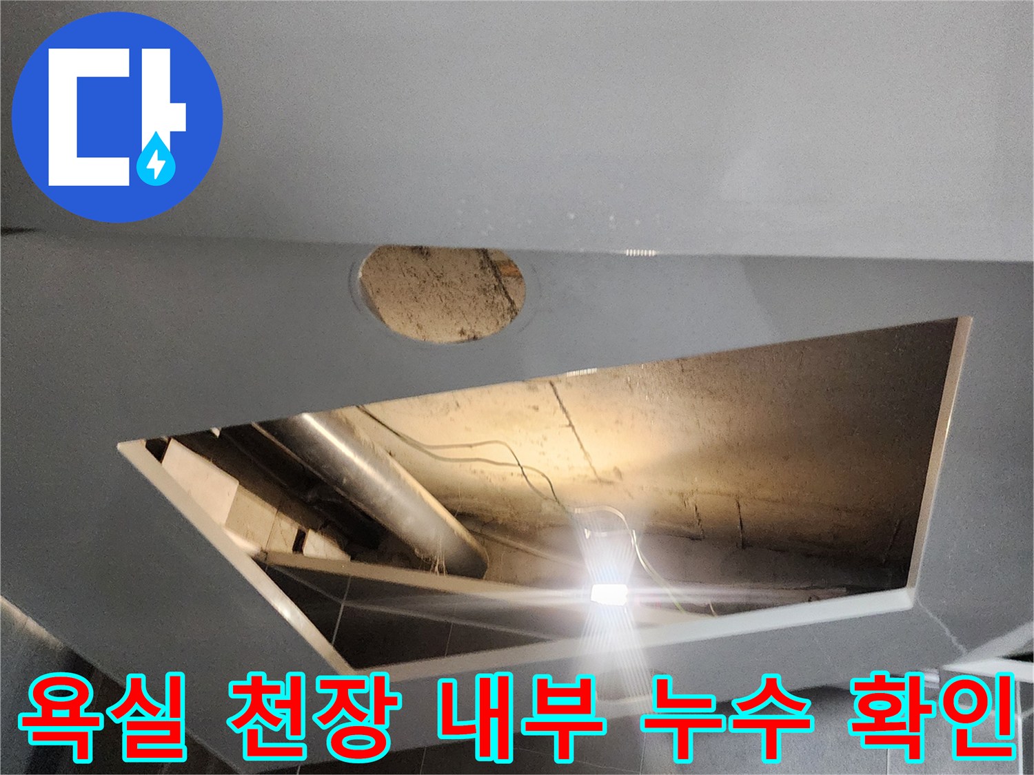 점검구 내부의 은색 배관과 습기가 찬 천장 안쪽 모습