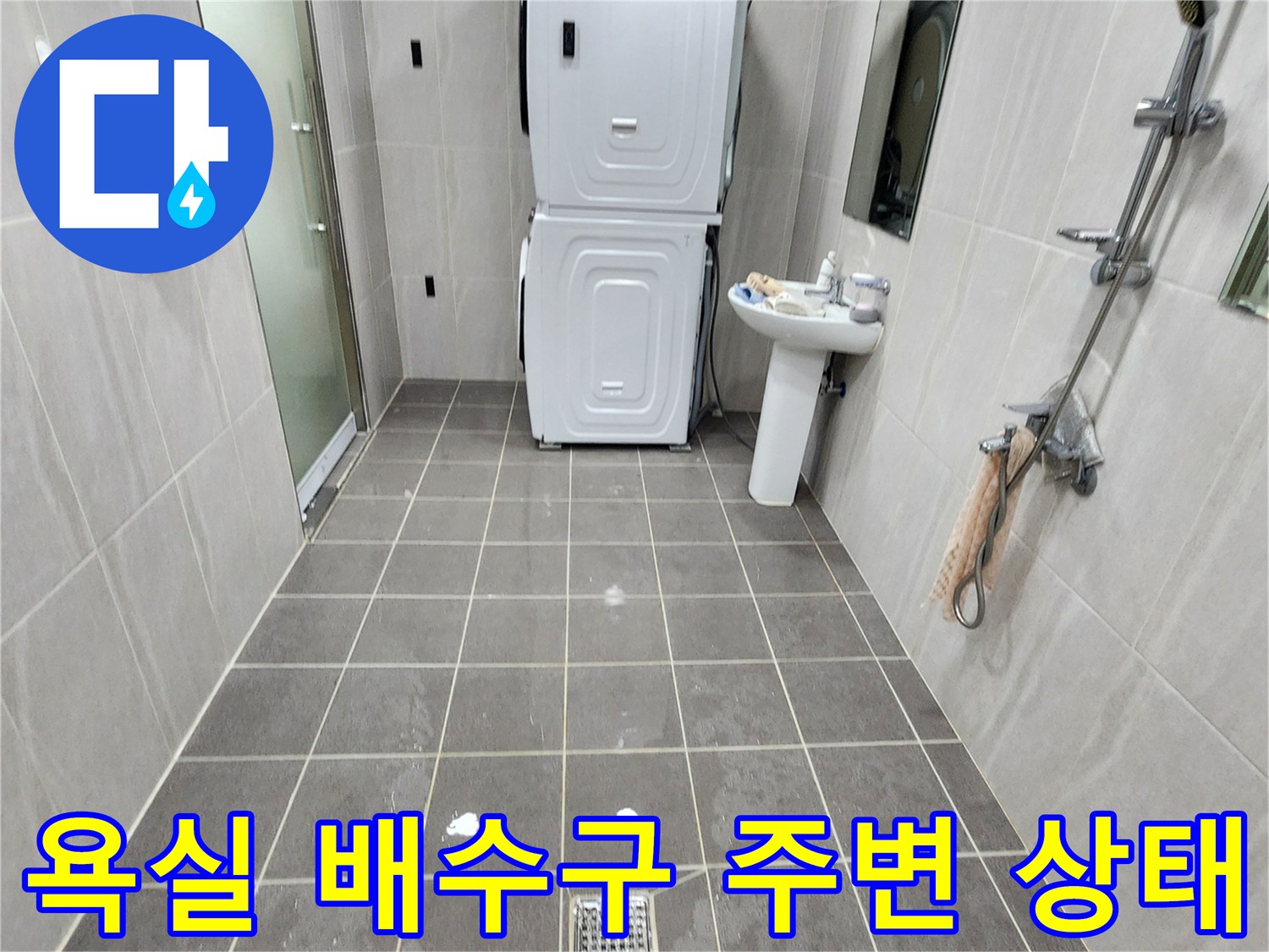 배수구와 세면대 하단부의 타일 마감 상태를 촬영했습니다.