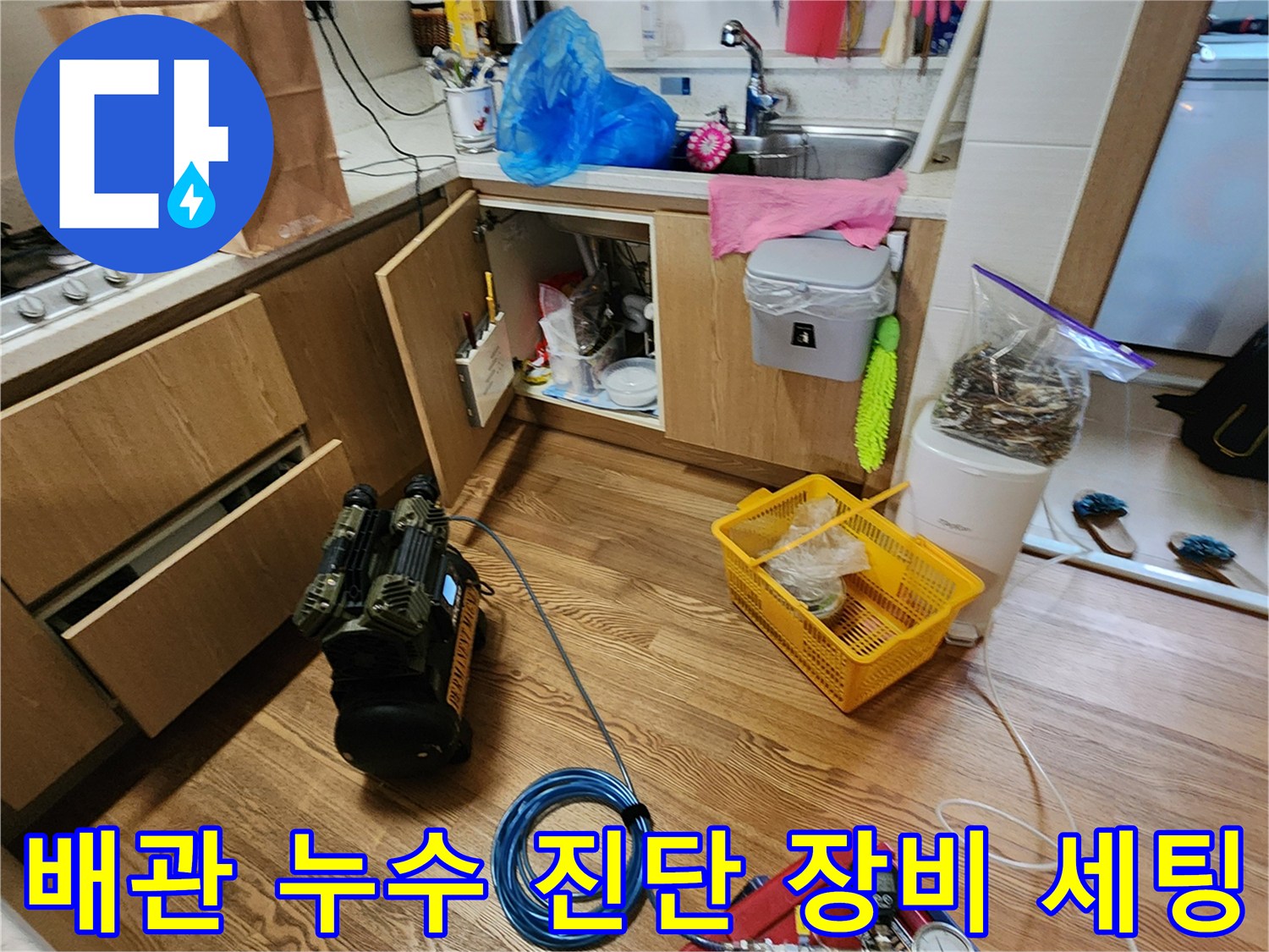 싱크대 하부 배관 점검을 위해 배치된 압력계와 펌프 장비