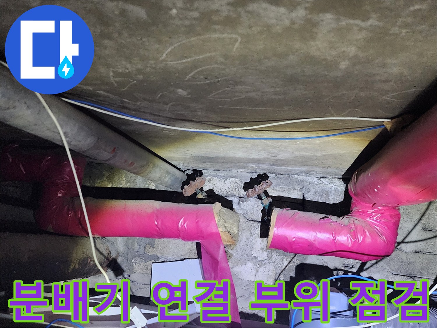 아파트 하부 천장에 위치한 분배기 연결 부위의 상태를 확인하는 모습