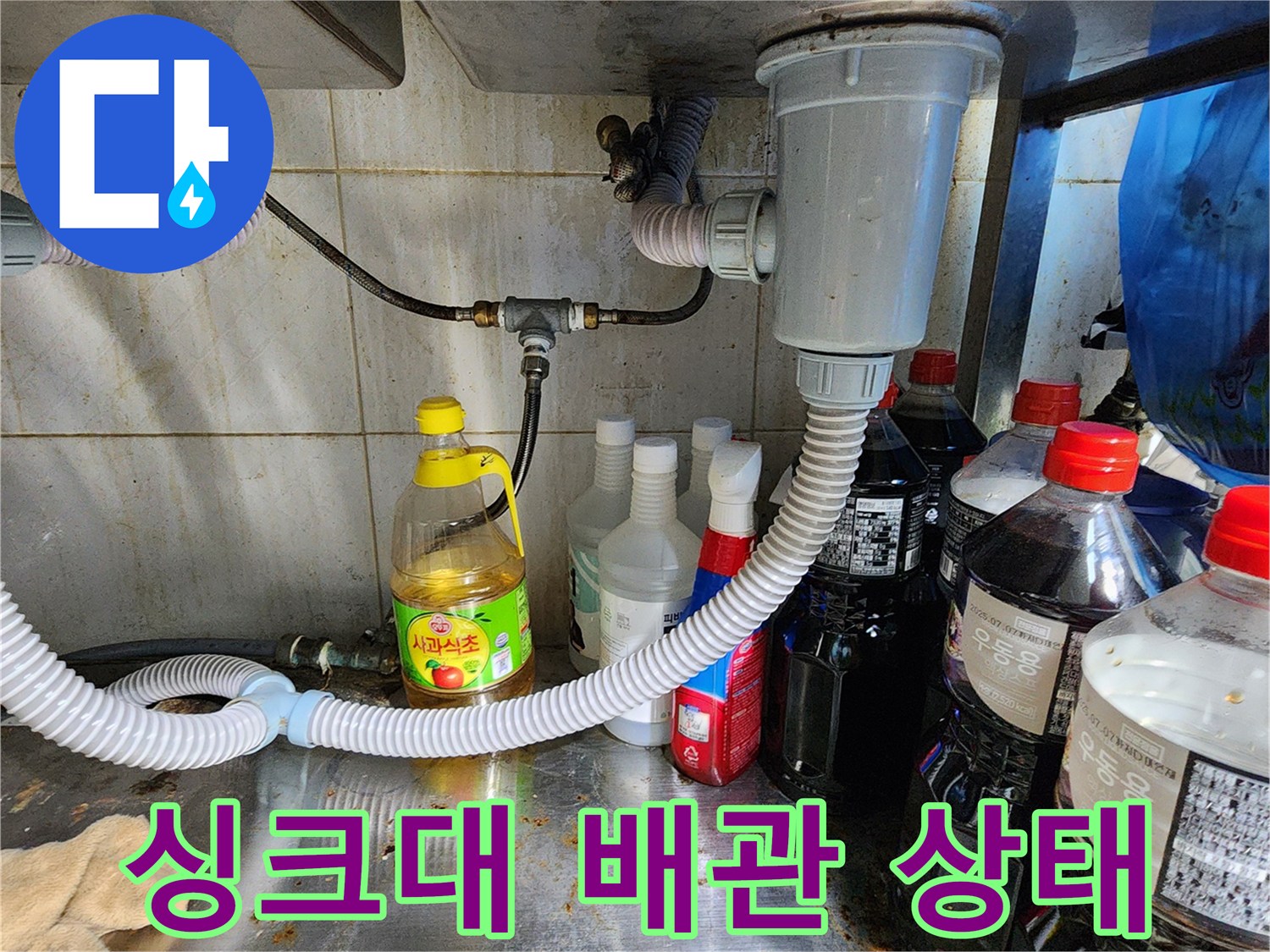 싱크대 하부장 내부의 배수 호스와 연결 부위 모습