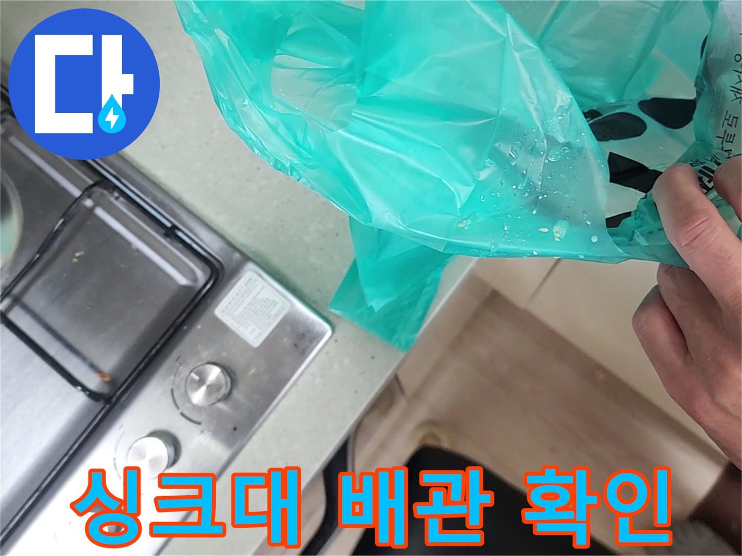 가스레인지 옆 싱크대 부근의 배관 누수 여부를 살피는 모습