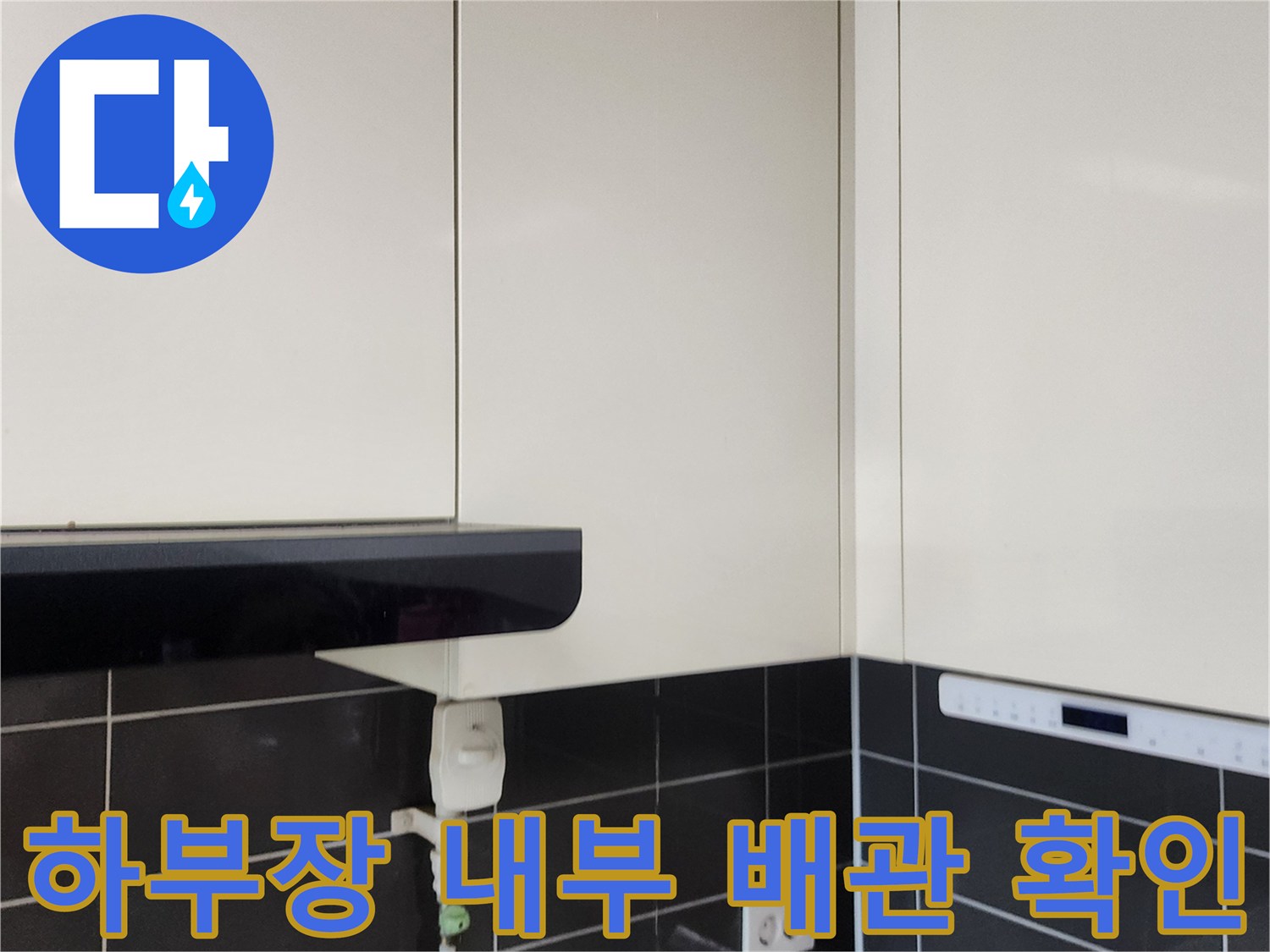 싱크대 아래쪽 배관과 전기 콘센트 주변의 상태를 보여주는 사진