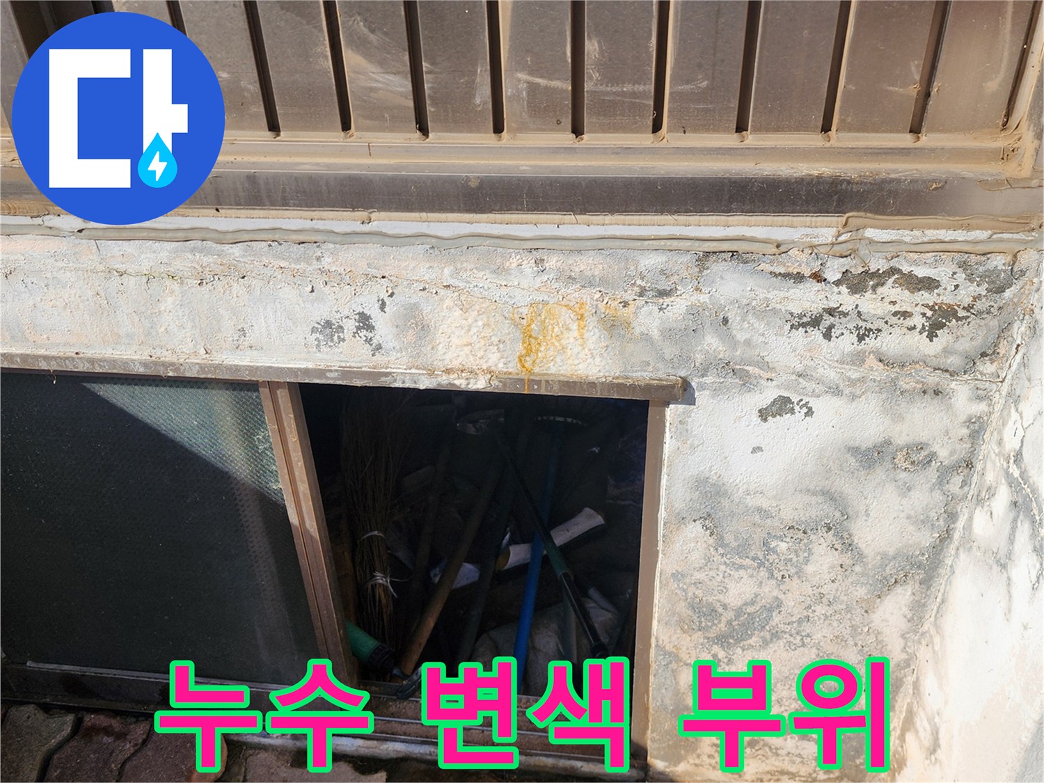 건물 외벽 마감재 아래의 누수 흔적과 노란 얼룩