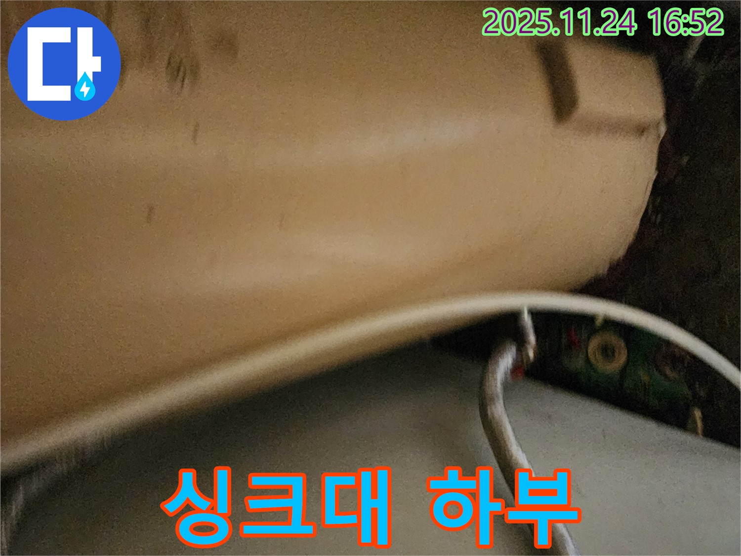 싱크대 하부의 복잡한 배관 - 누수가 발생하기 쉬운 싱크대 하부의 복잡한 배관 연결 상태를 보여줍니다.