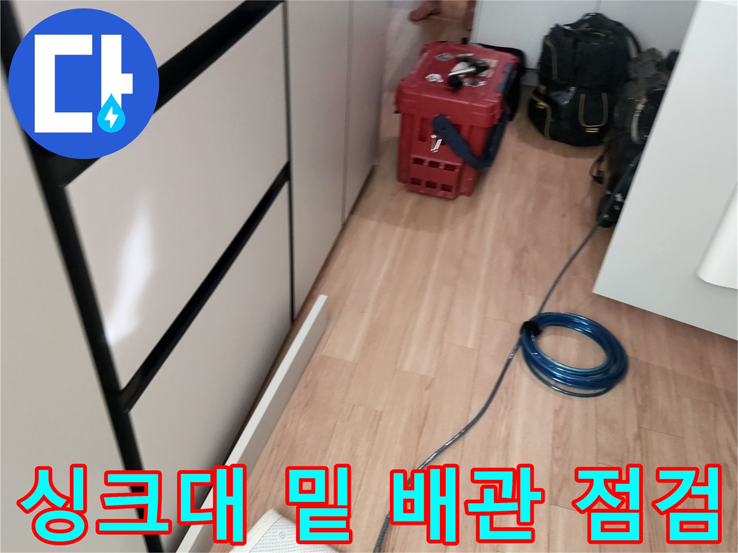 싱크대 하부 공간에 배치된 누수 탐지용 전문 장비와 호스