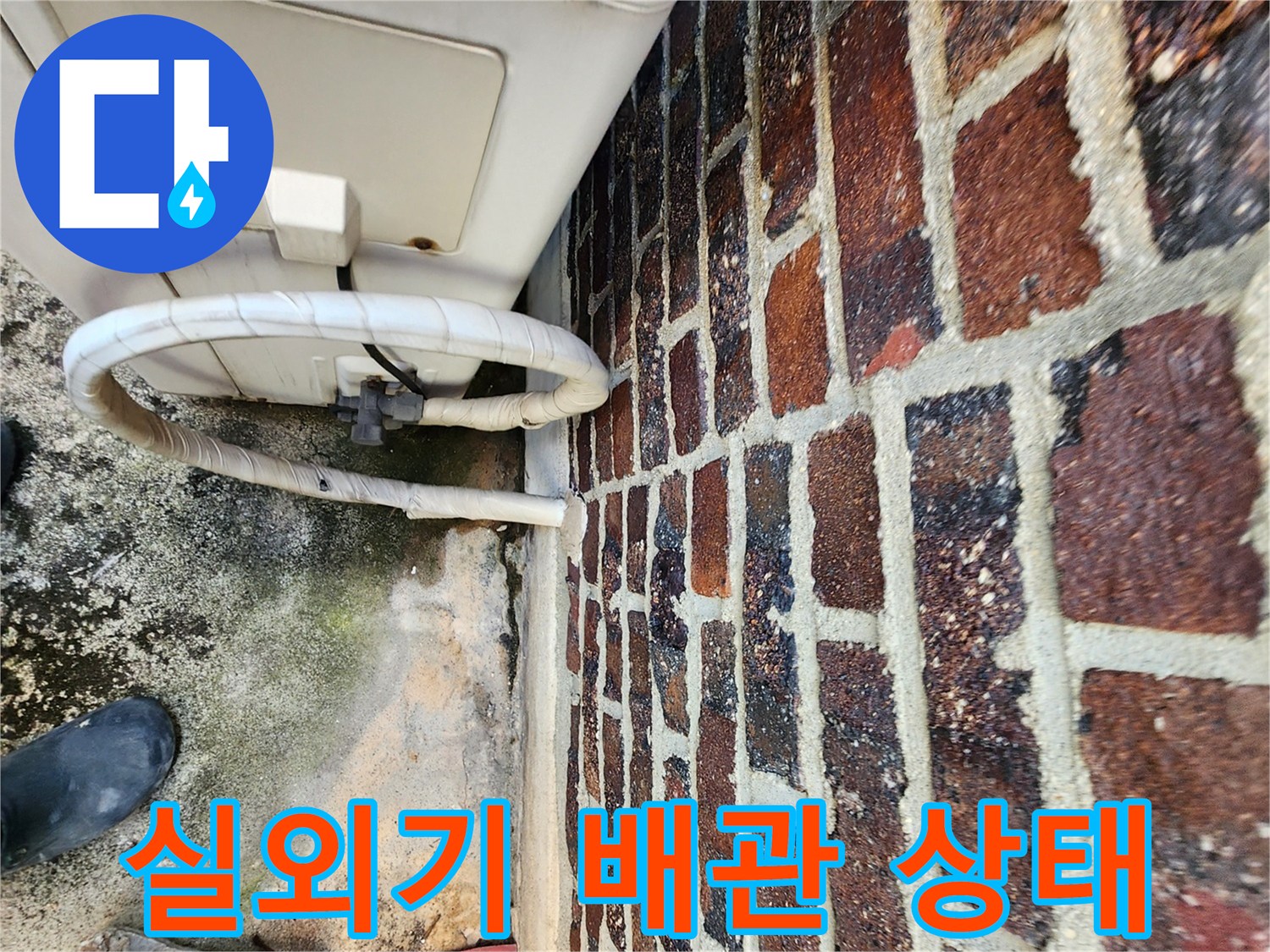 에어컨 실외기 연결 배관과 벽돌 외벽의 접합부 근접 촬영