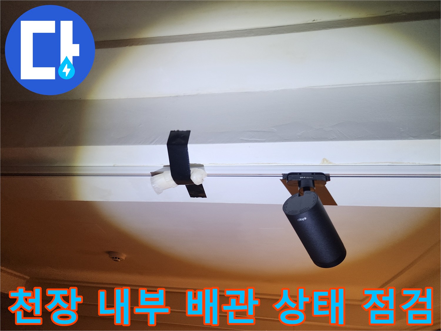 천장 틈새에 설치된 검은색 배관 부속과 장비 확인