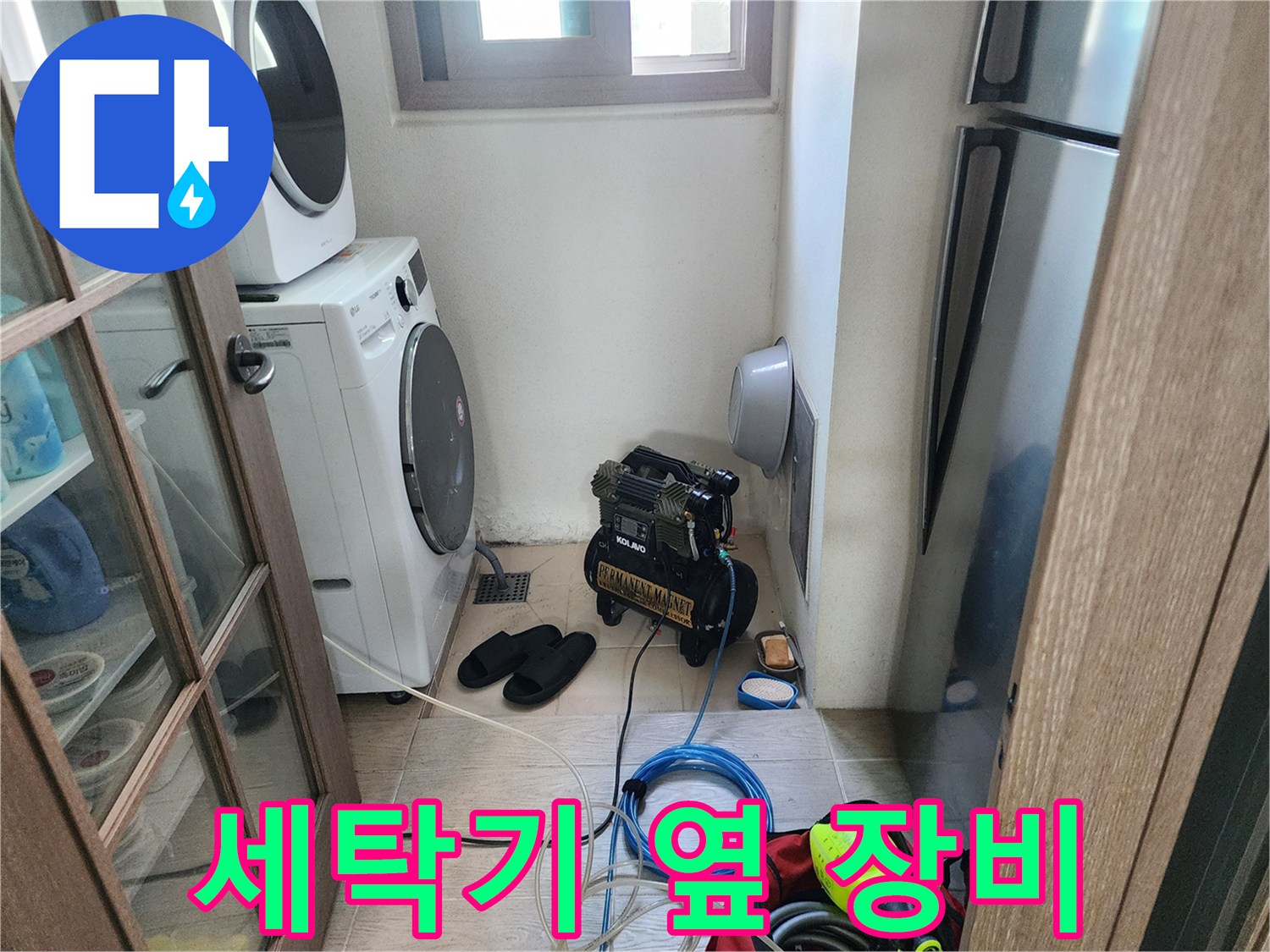 건조기와 세탁기 사이 공간에 설치된 배관 검사용 압축기