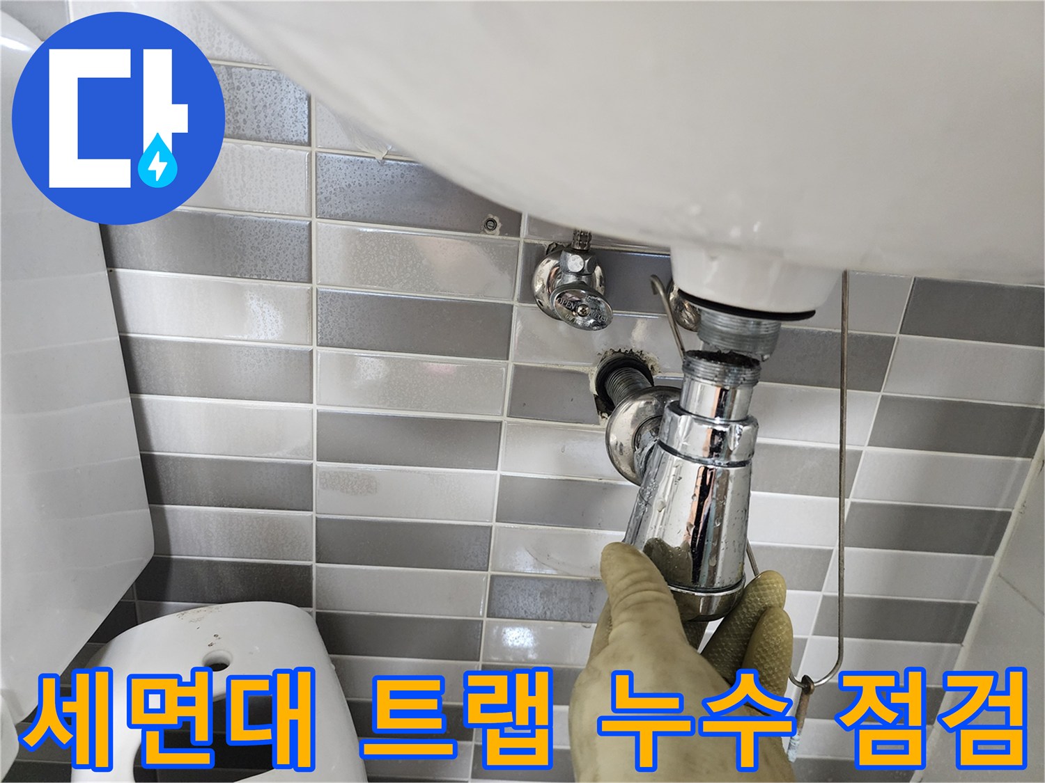 세면대 아래쪽 금속 부품을 손으로 만지는 작업 현장