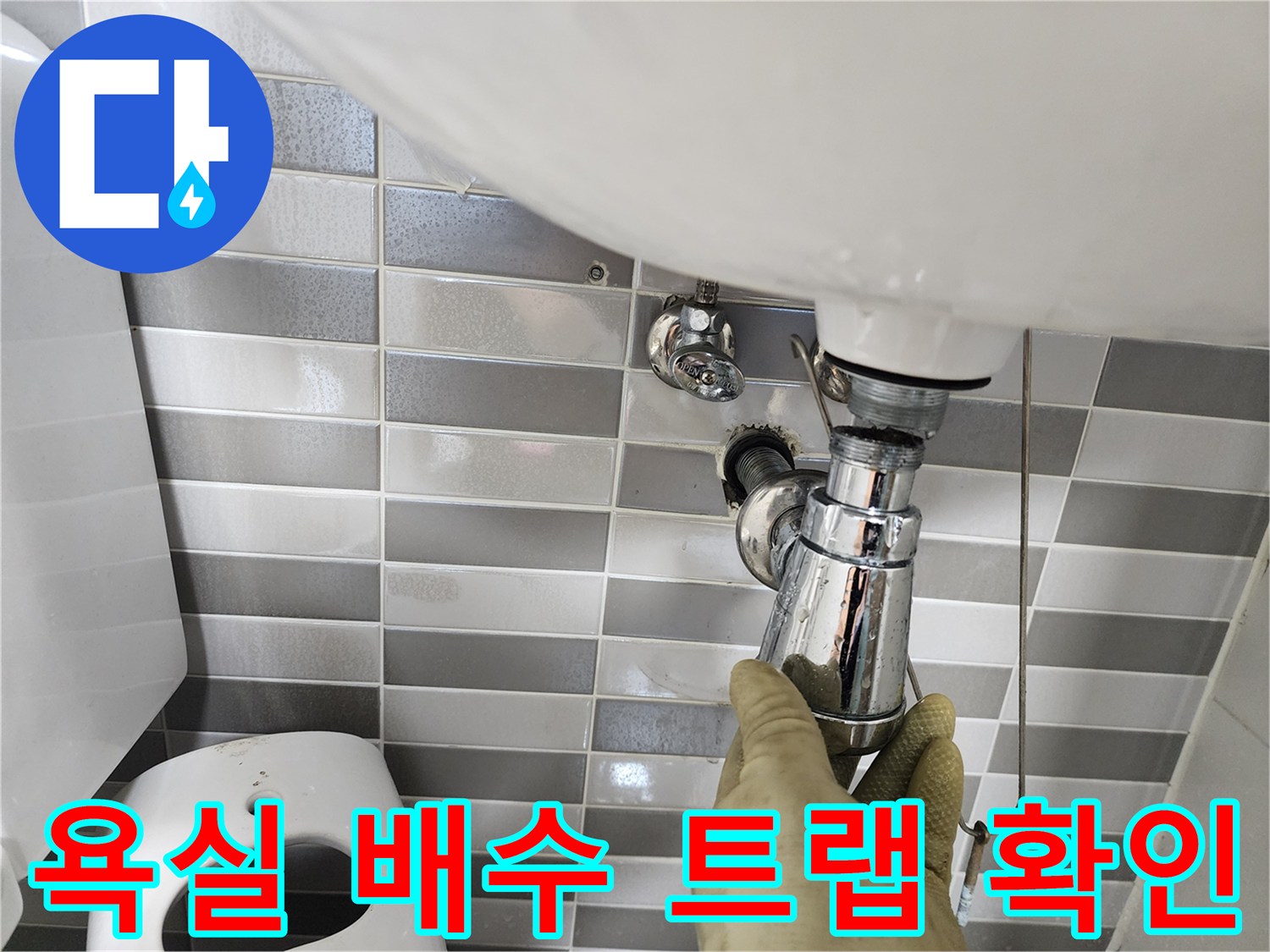 세면대 하부의 금속재질 팝업 배관을 점검 중인 사진