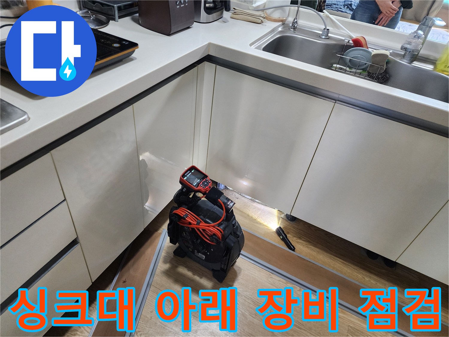 주방 싱크대 하부장에 놓인 누수 탐지용 전문 장비