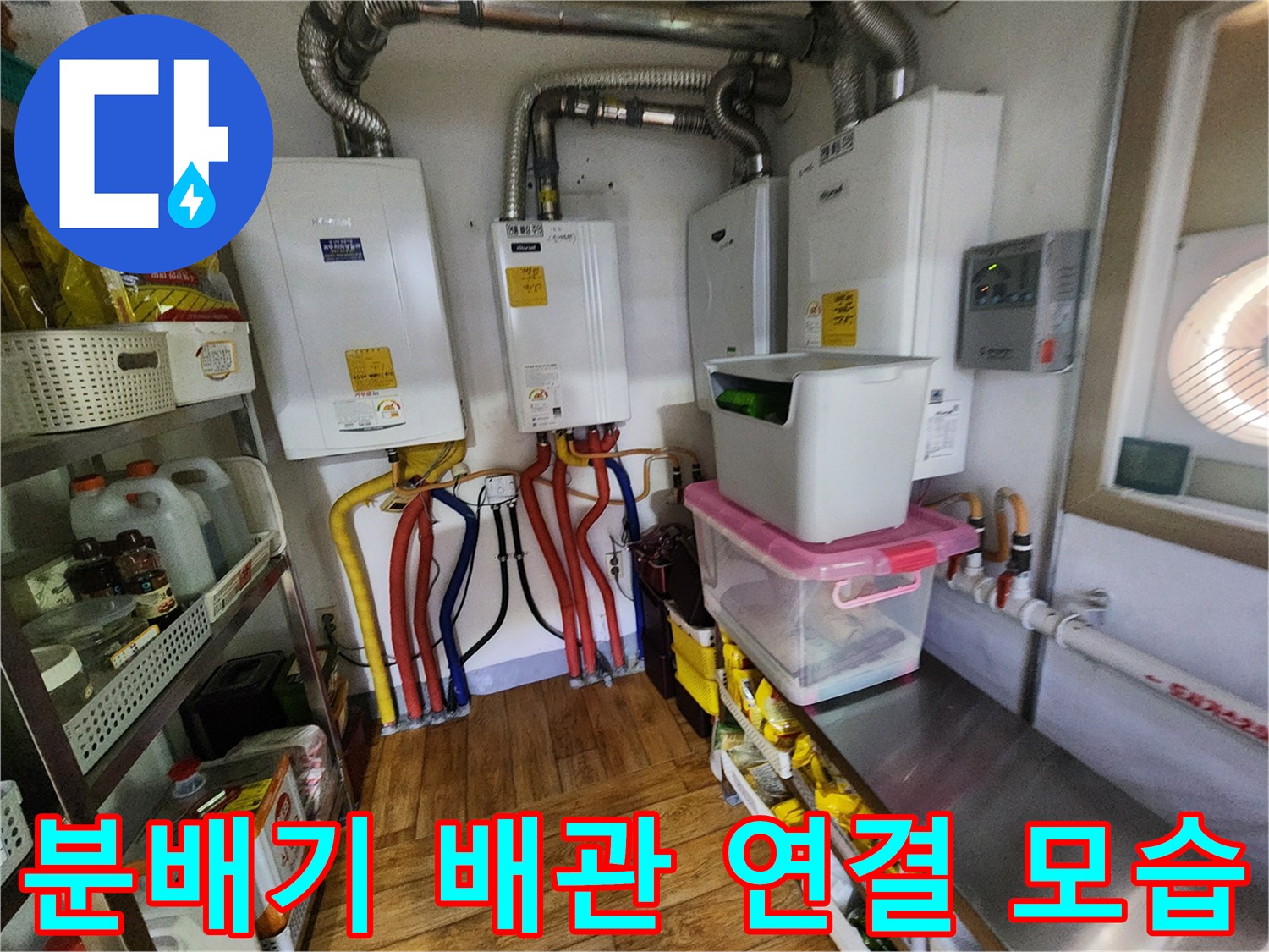 주방 하부장에 설치된 보일러 분배기와 유연한 금속 배관들