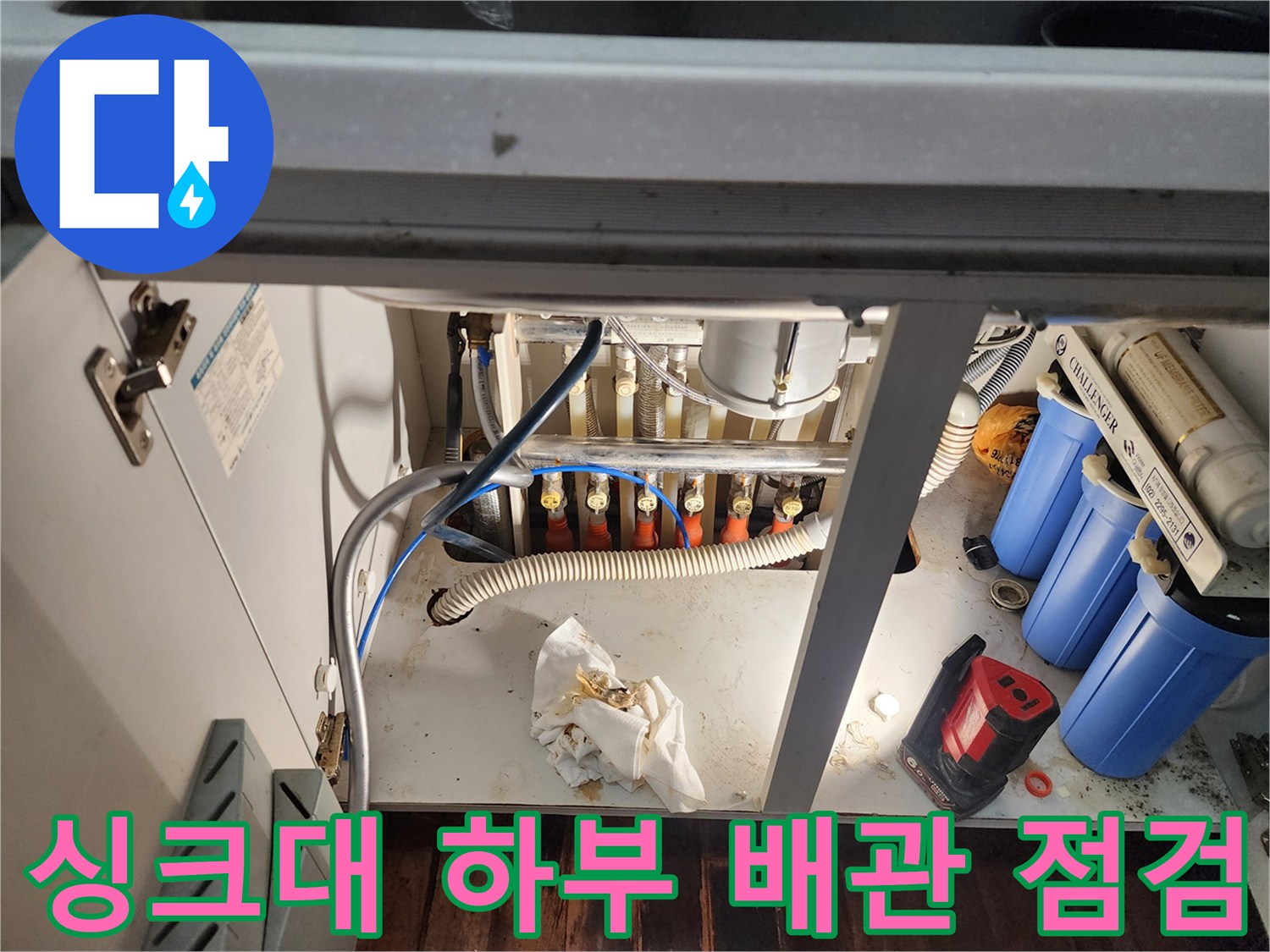 복잡하게 얽힌 싱크대 하단 수도 배관과 필터 장치