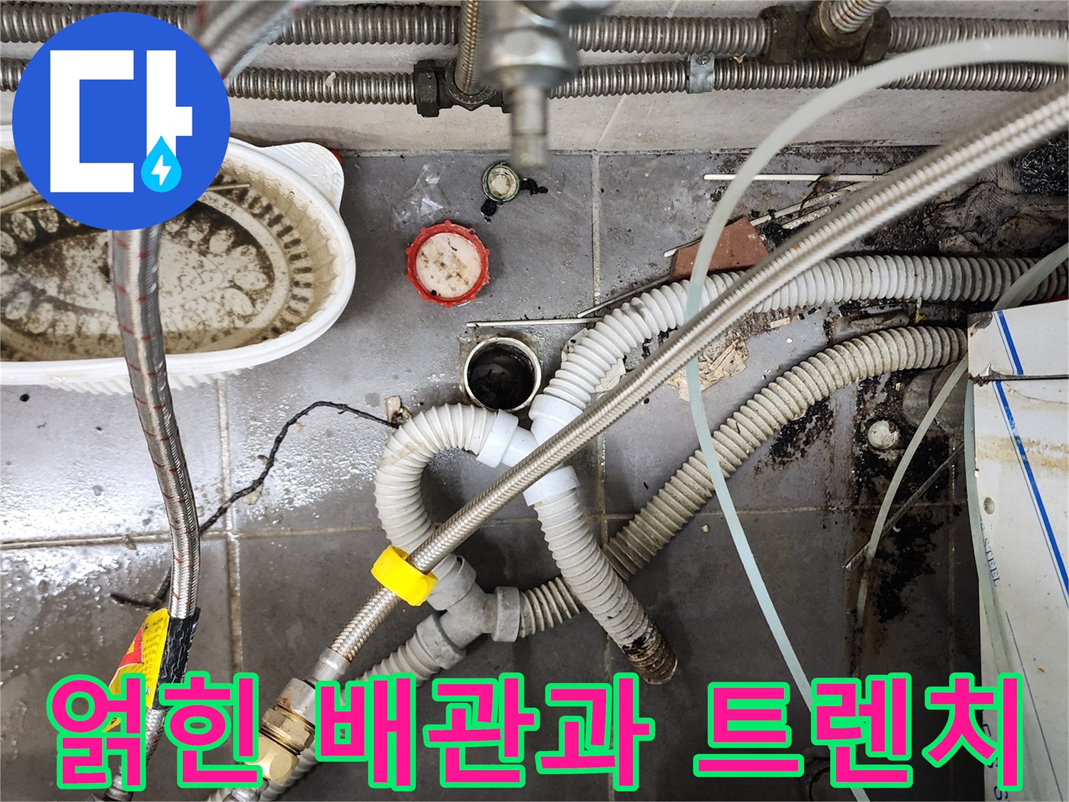 식당 주방 내부-배수구 주변의 복잡한 호스와 배관 구조