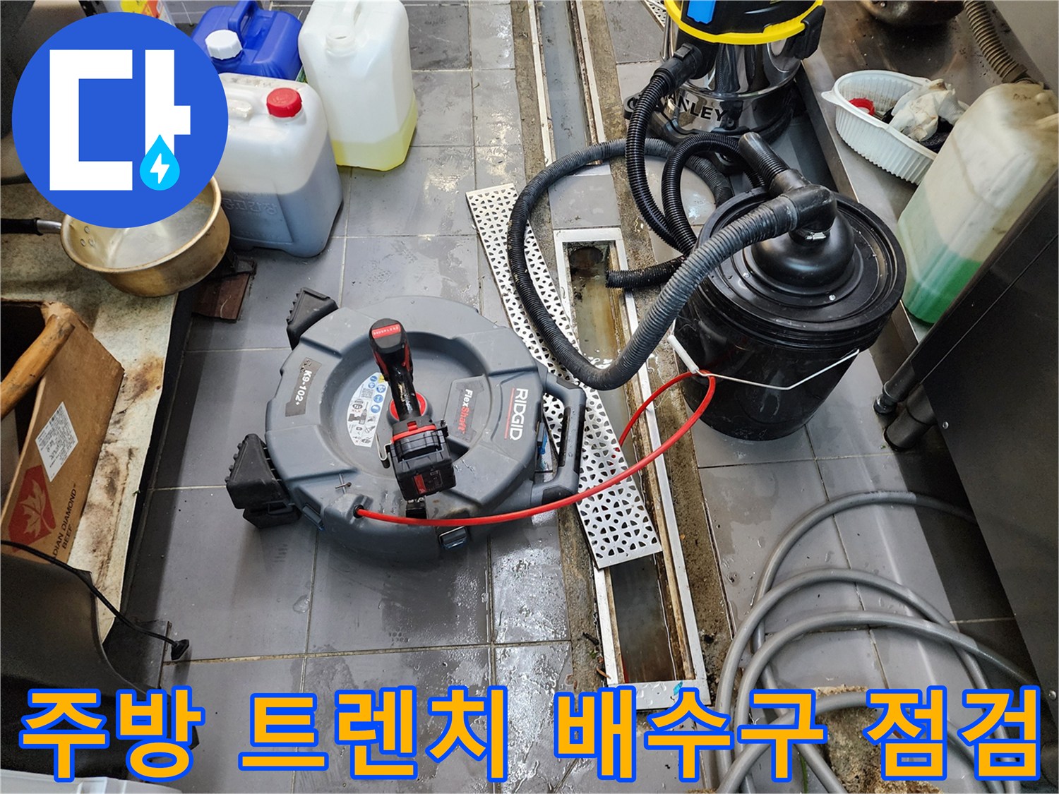식당 주방 바닥 트렌치 주변에 설치된 전문 진단 장비와 흡입기
