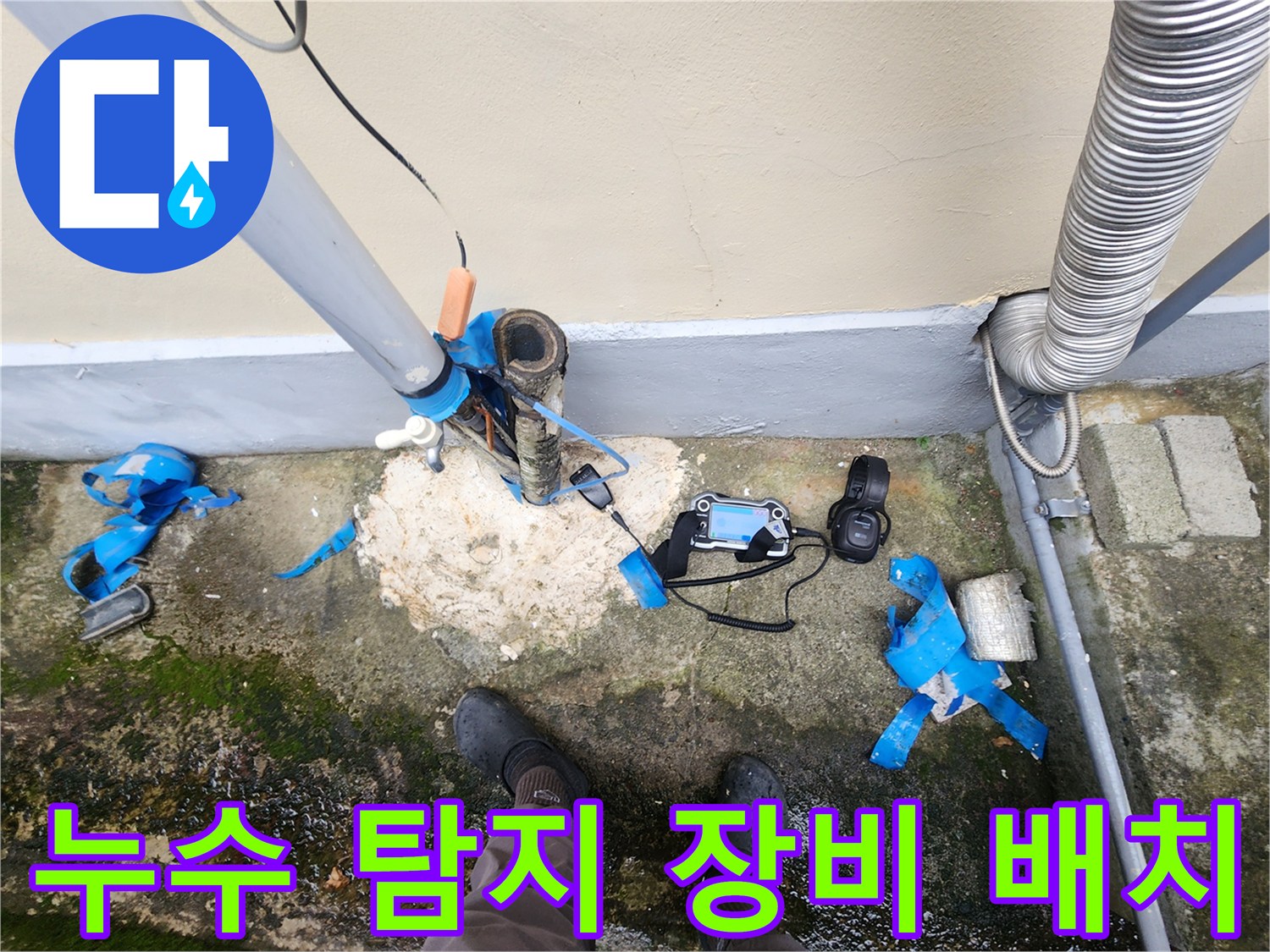 외부 배관 주변의 젖은 지면과 놓여있는 누수 탐지 기기들