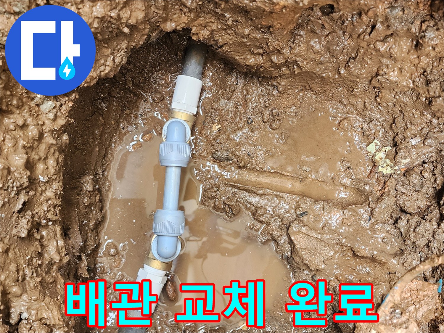 젖은 흙 사이로 드러난 새롭게 시공된 배관 연결 부위
