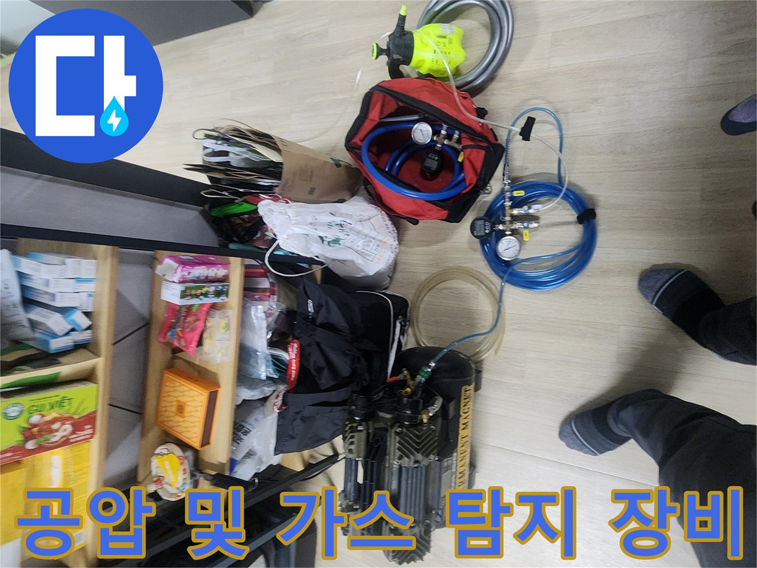 바닥에 놓인 파란색 호스와 압력 측정용 공압 테스트기