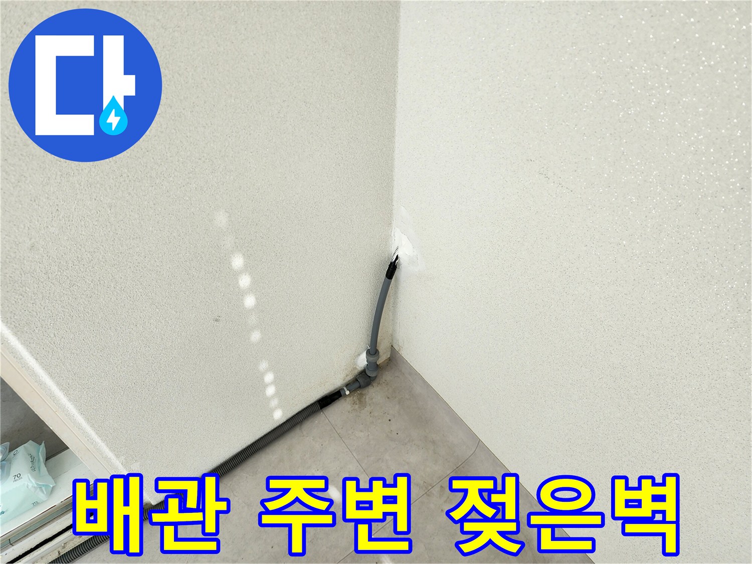 베란다 구석 배관 주변의 젖은 벽면 모습