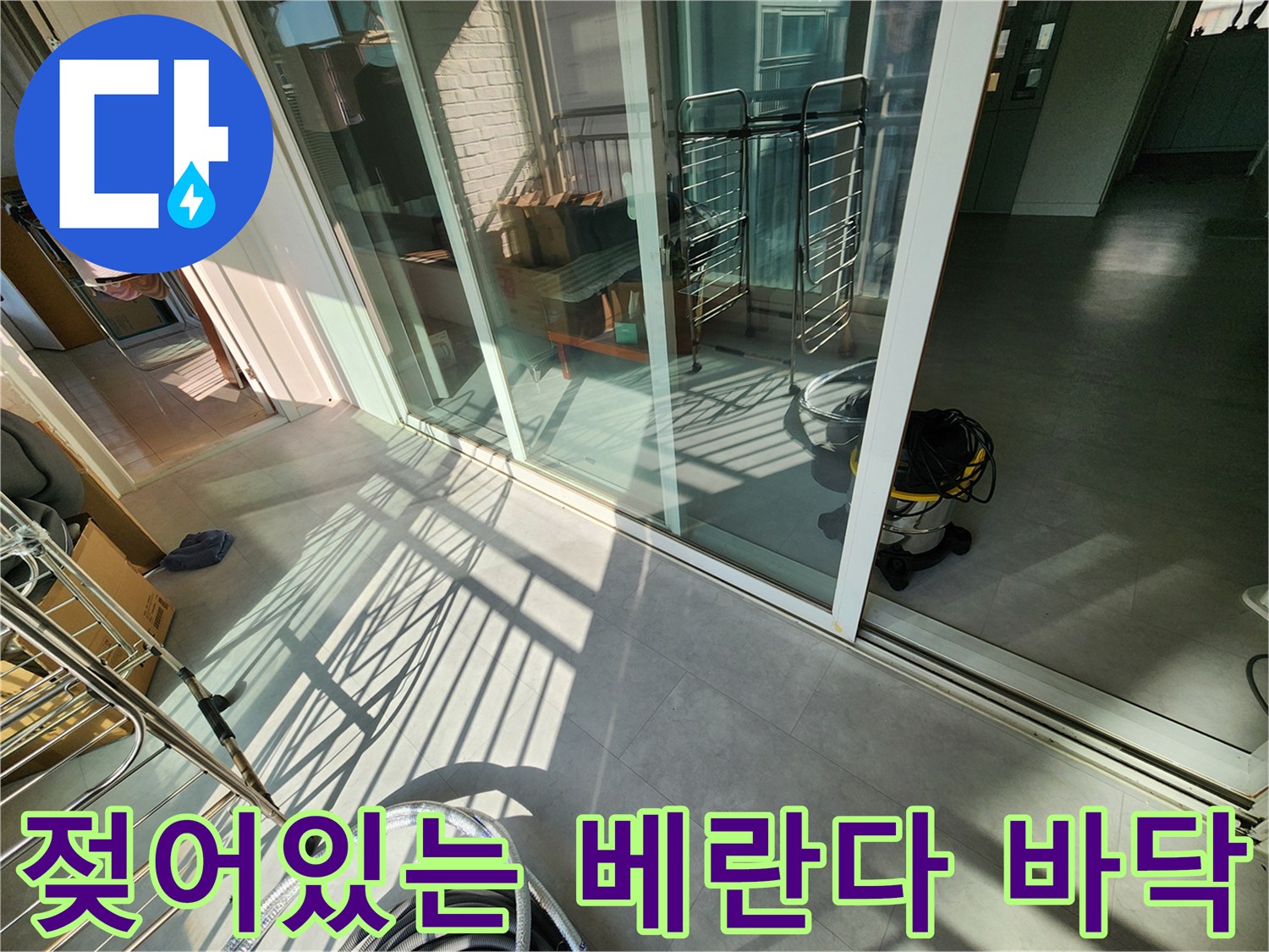 베란다 창가 쪽 타일이 젖어 있는 모습을 촬영한 사진입니다.