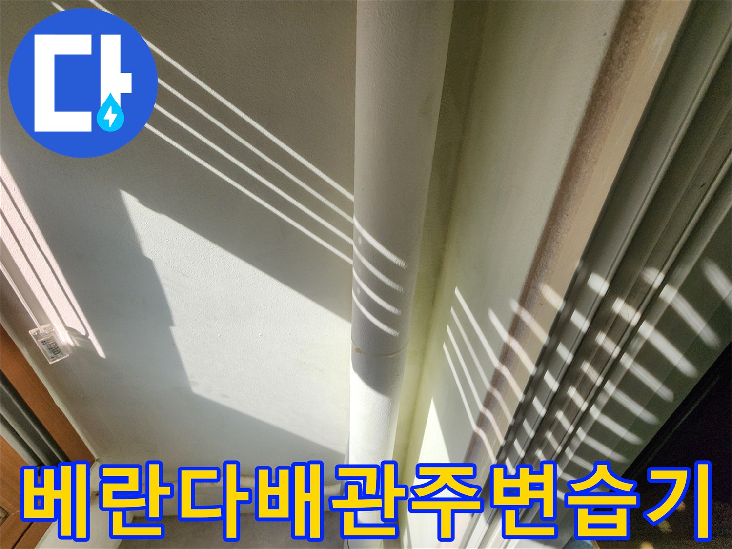 벽면에 수직으로 내려오는 배관과 주변 벽면의 상태를 촬영했습니다.
