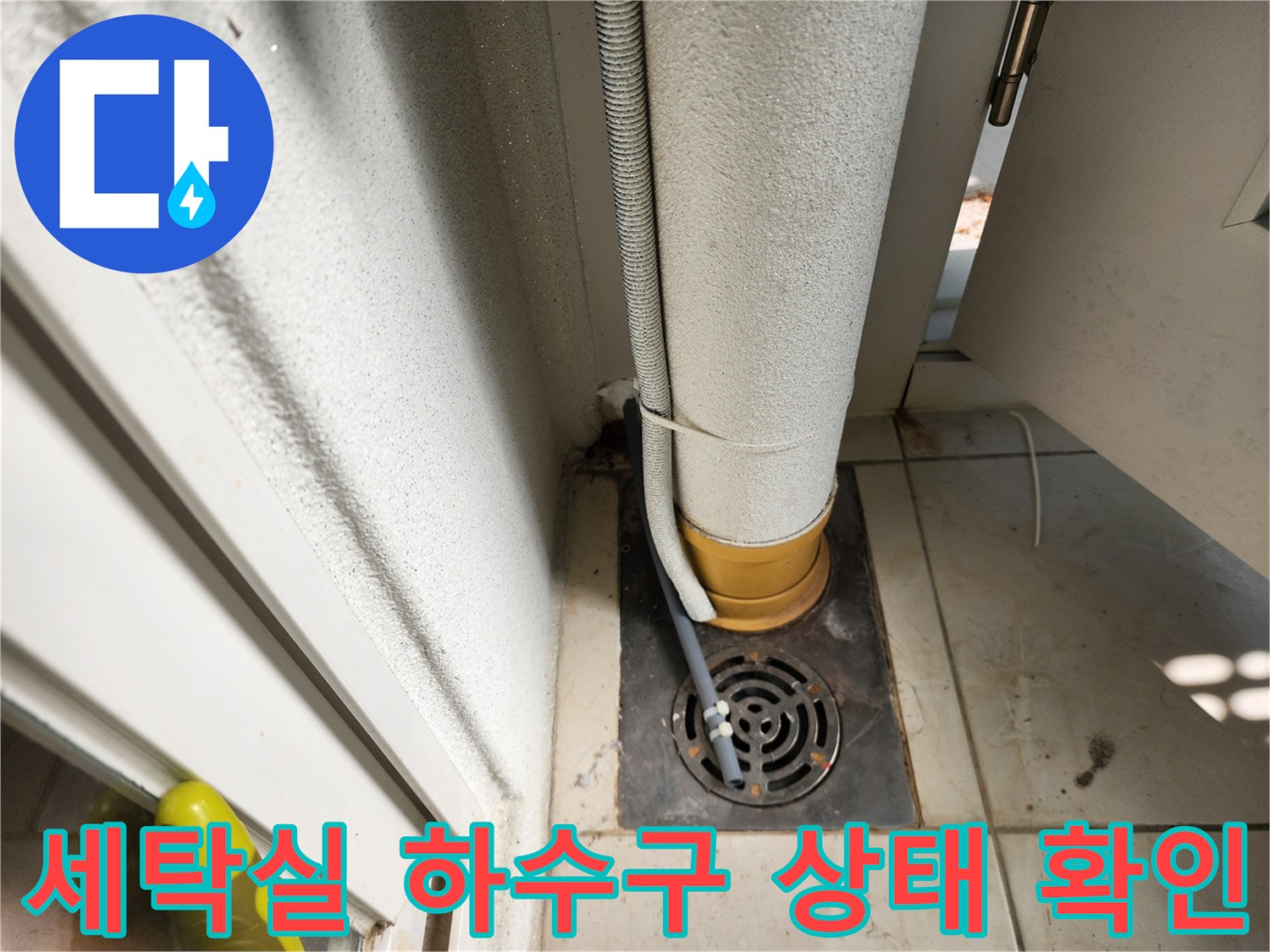 하수구 배수구 주변에 고여 있는 습기와 노후된 배관 연결 부위의 모습입니다.