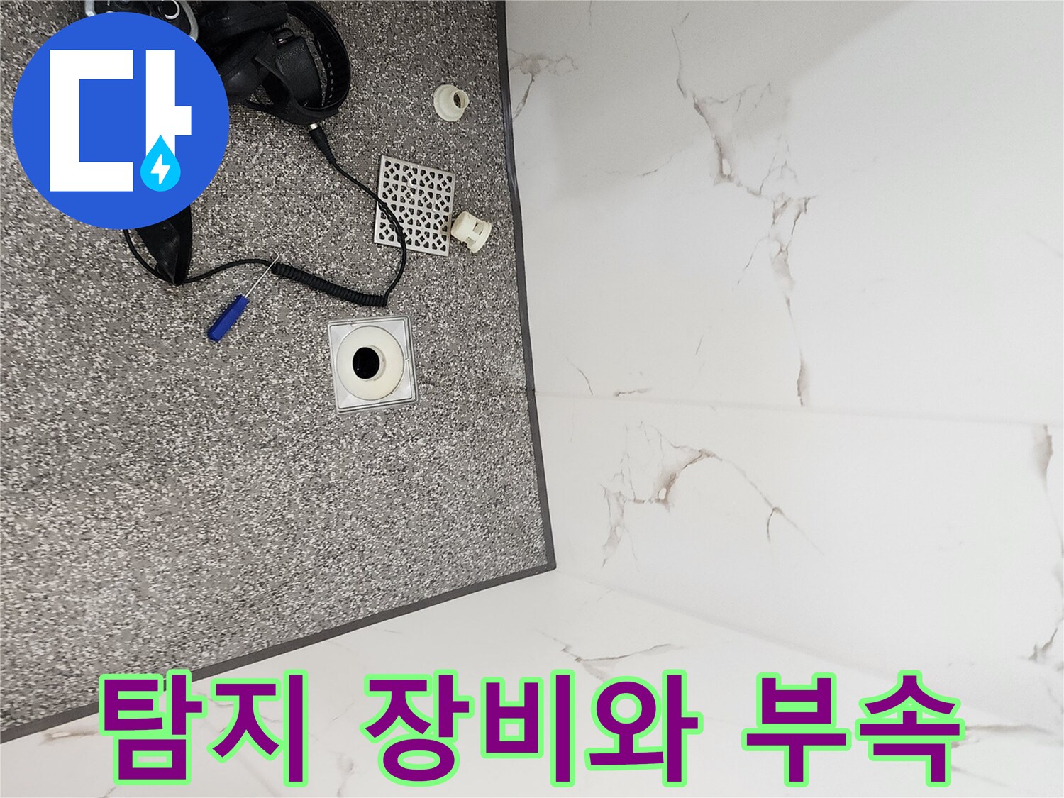 바닥 타일 위 가스 탐지기와 배수구 주변의 자재들